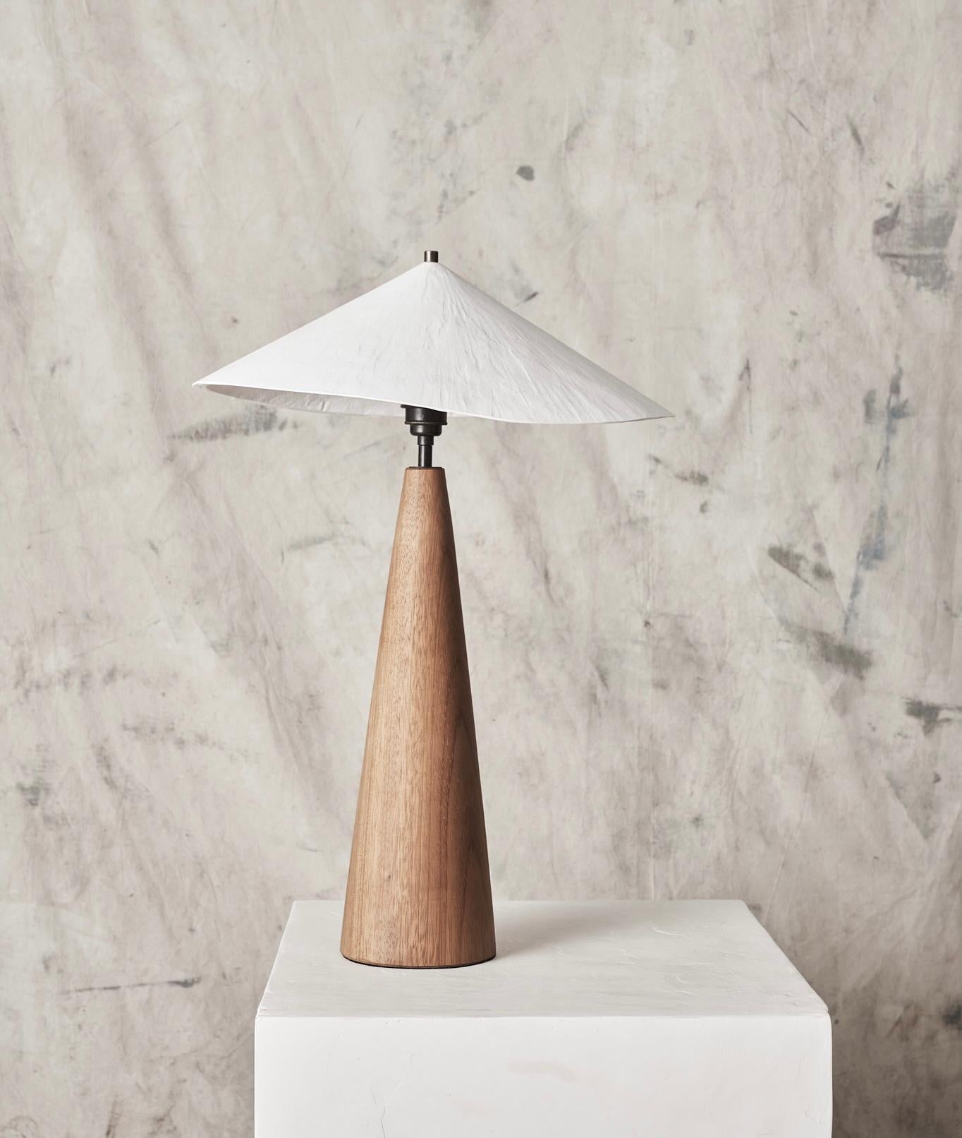 The Wobble Table Lamp casts a warm downwards light, creating an atmospheric glow to any room. 
Incorporating our original scaled down plaster wobble shade, paired with a beautiful hand turned iroko wooden base, the Wobble Table Lamp offers a