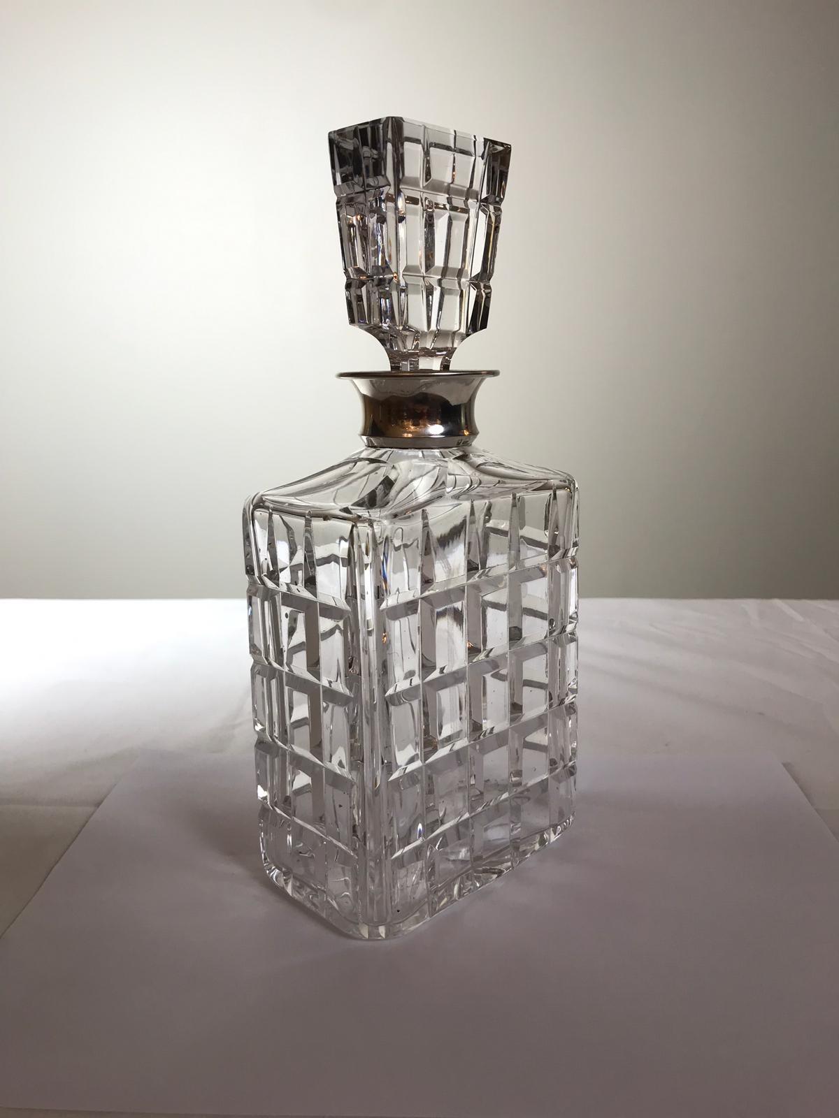 A crystal decanter and lid made by Wolfers Freres with a silver collar. The collar is marked 925 and has the Wolfers Freres stamp.