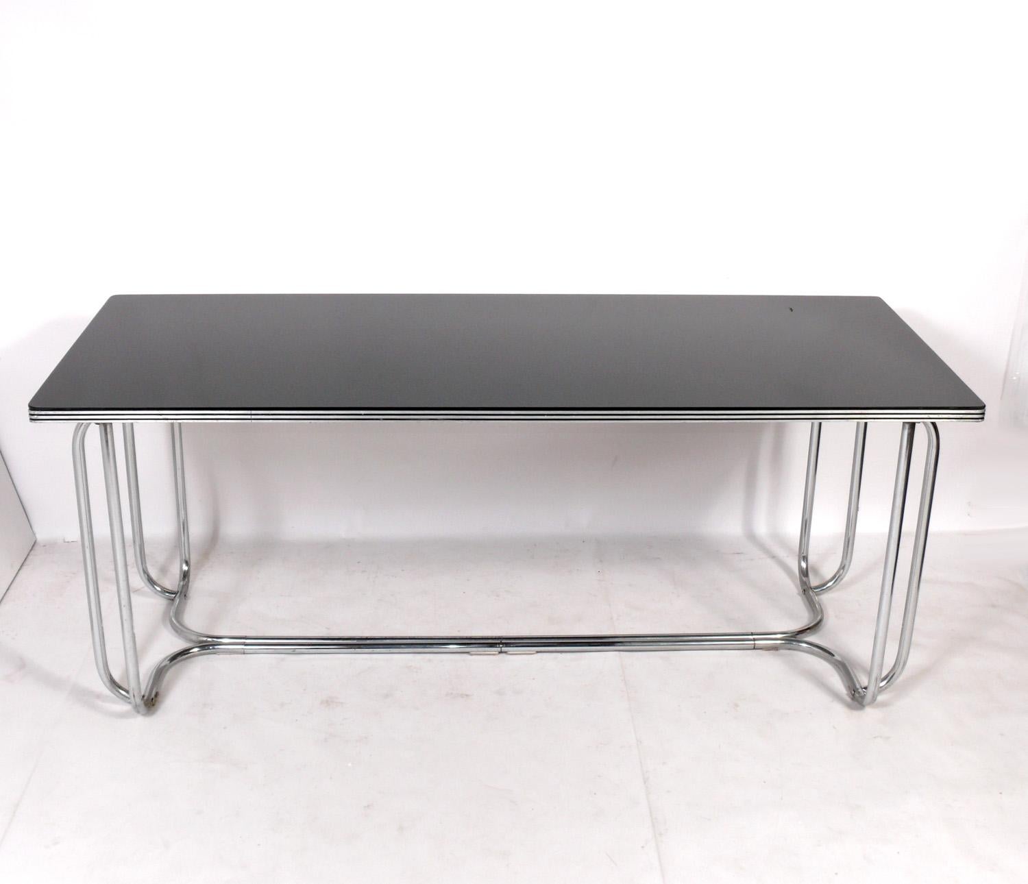 Streamlined Art Deco dining table, designed by Wolfgang Hoffmann for Howell, American, circa 1930s. Chrome plated metal frame with sleek black glass top. Please see our other 1stdibs listings for the Hoffmann dining chairs from the same estate. See