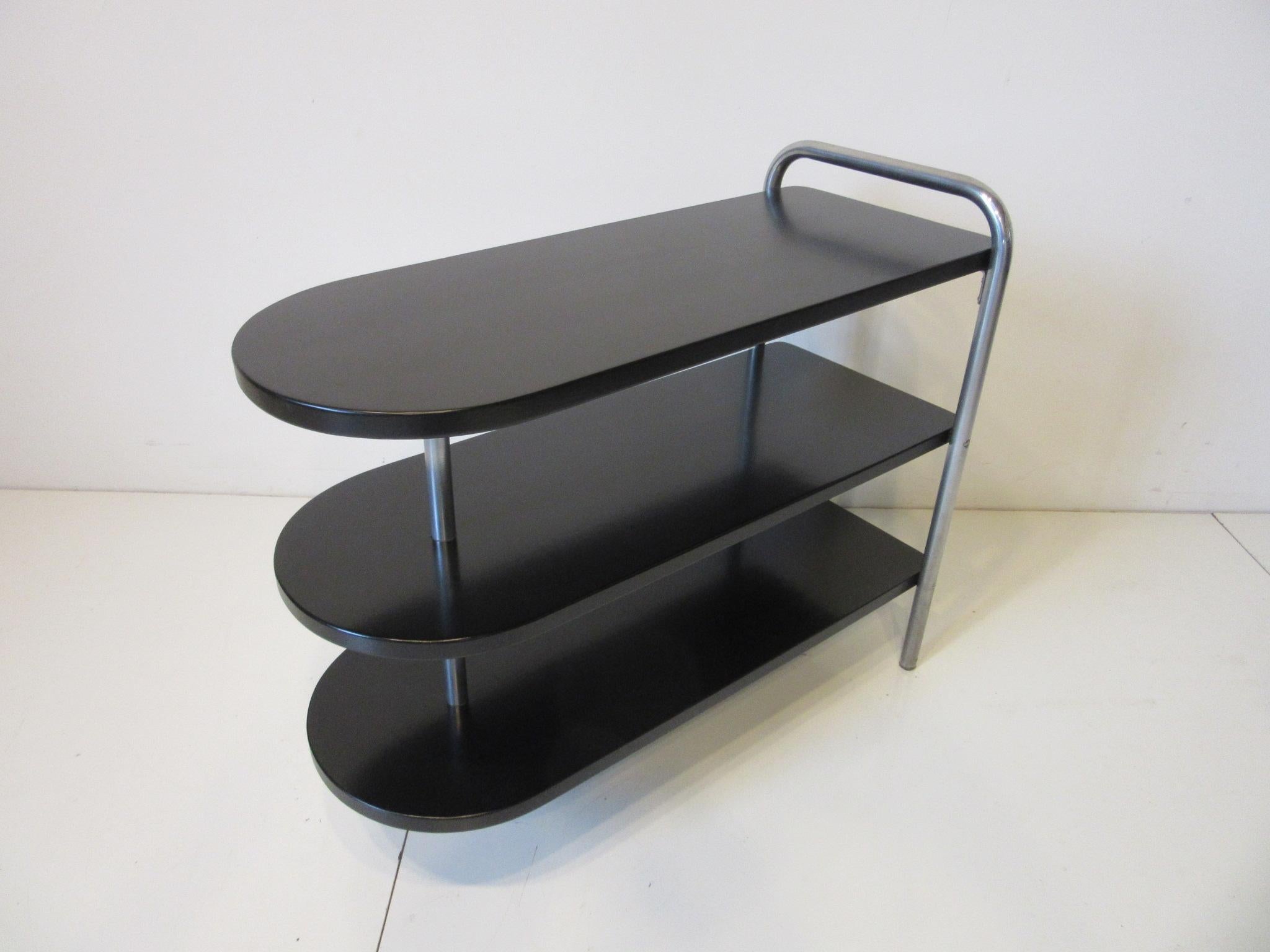 A satin black wood topped tri tiered Machine Age / Art Deco side table with chromed legs and retaining the original label to the bottom. Manufactured by the Howell Modern Metal Furniture Company.