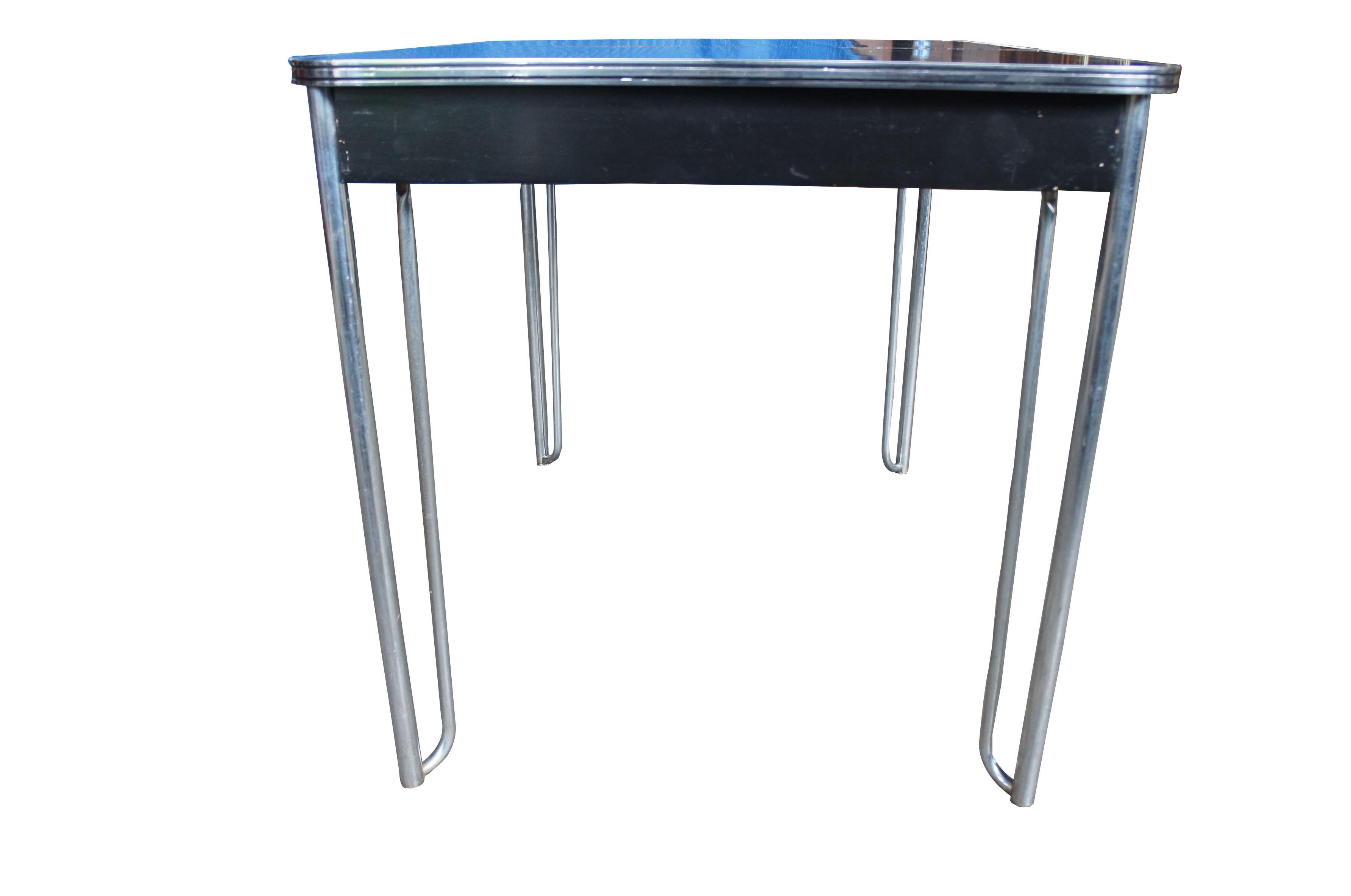 Art Deco breakfast table designed by Wolfgang Hoffmann for Howell Furniture. 
Features a tubular machine age design with black Micarta top.

Micarta tops came before formica, and was the original brand name created by George Westinghouse for