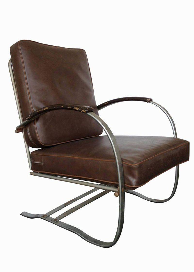 A pair of Wolfgang Hoffmann Art Deco chrome and wood springer lounge chairs for Howell furniture, these chairs consist of a chromed flat iron frame that seamlessly forms to shape the legs, arms and back support of the streamlined seat. The arms are