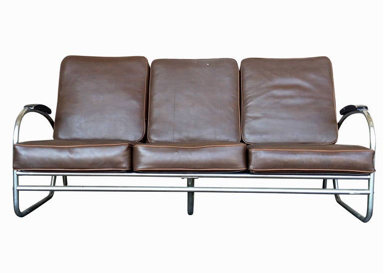 Made by Royal Metal Manufacturing, this Wolfgang Hoffmann style sofa features a heavily made chromed round tubular frame with heavy double bated cushion. 

The arms of the sofa feature graceful streamline moderne shapes connected to a double pole