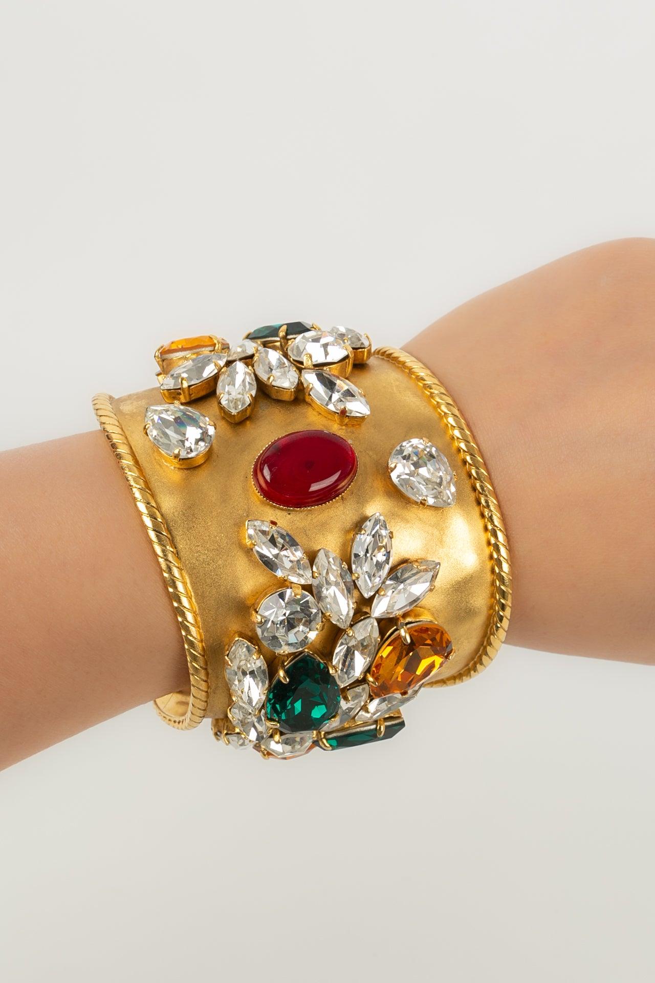 Woloch - Bracciale in metallo dorato ornato con strass e cabochon in pasta di vetro.

Informazioni aggiuntive:
Condizioni: Ottime condizioni
Dimensioni: Circonferenza: 17 cm - Apertura: 2/3 cm - Altezza: 6 cm

Riferimento del venditore: BRA11