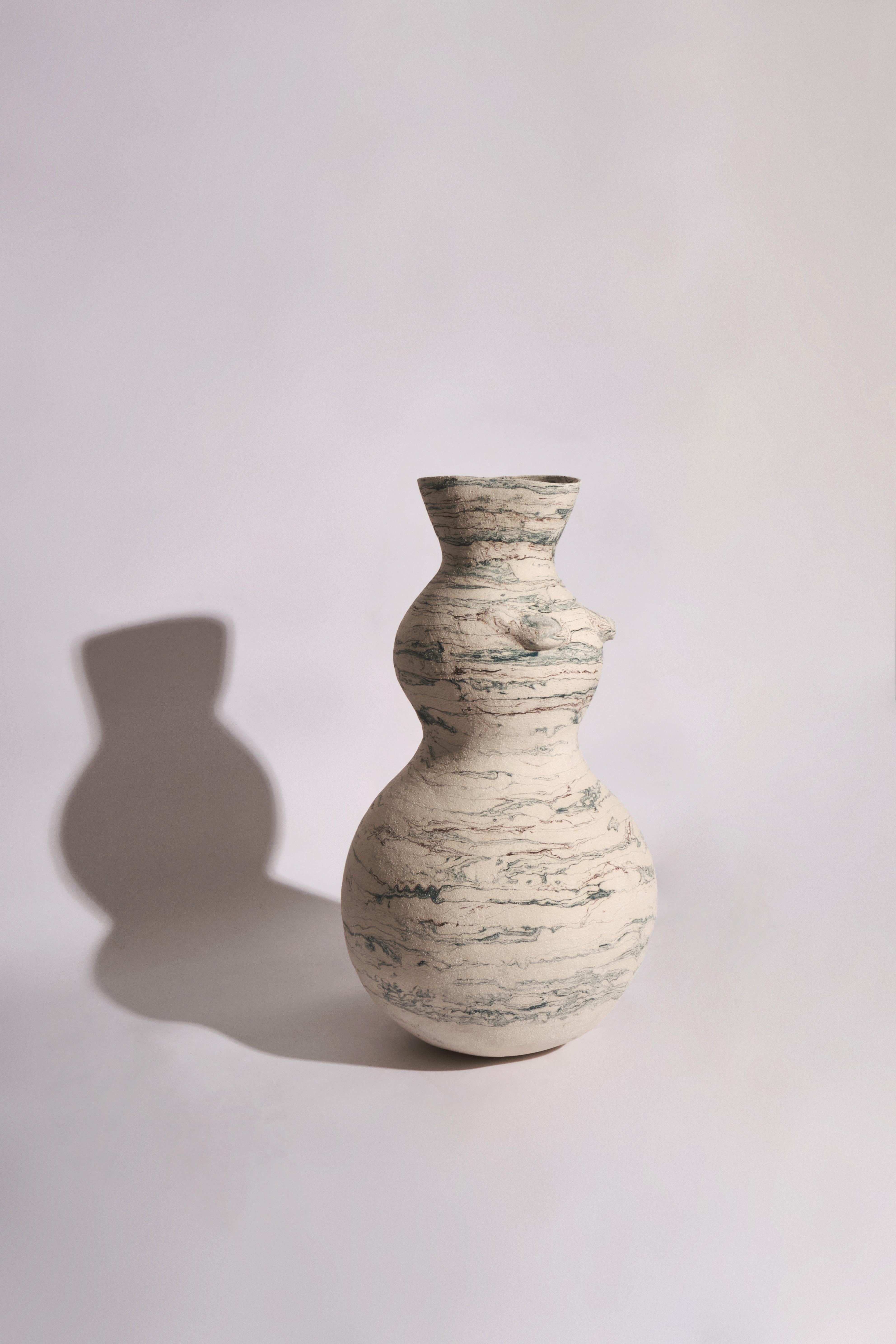 The ceramic body vessel, standing at a 70 cm  in height, is a creation that elegantly embodies the duality of clay - fragile yet strong, much like the resilience of a woman. The coiling method i employed to craft this piece adds depth and texture to