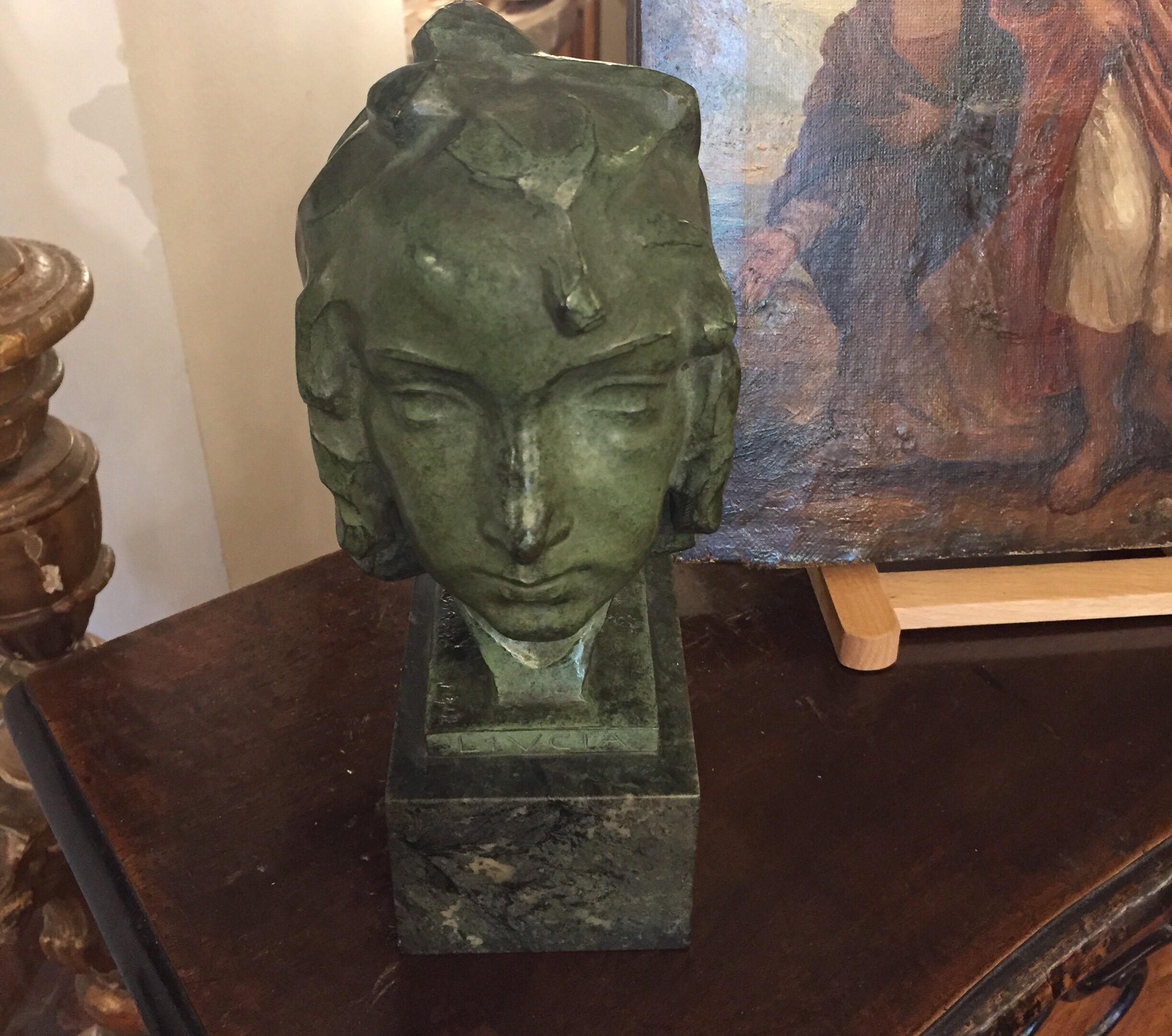 LUCIA, a lovely green patina bronze casting figurative sculpture of a girls's head with waving hair, entitled on the bronze base Llucia, standing on a green marble basement.
This antique Italian bronze sculpture is signed, entitled and dated