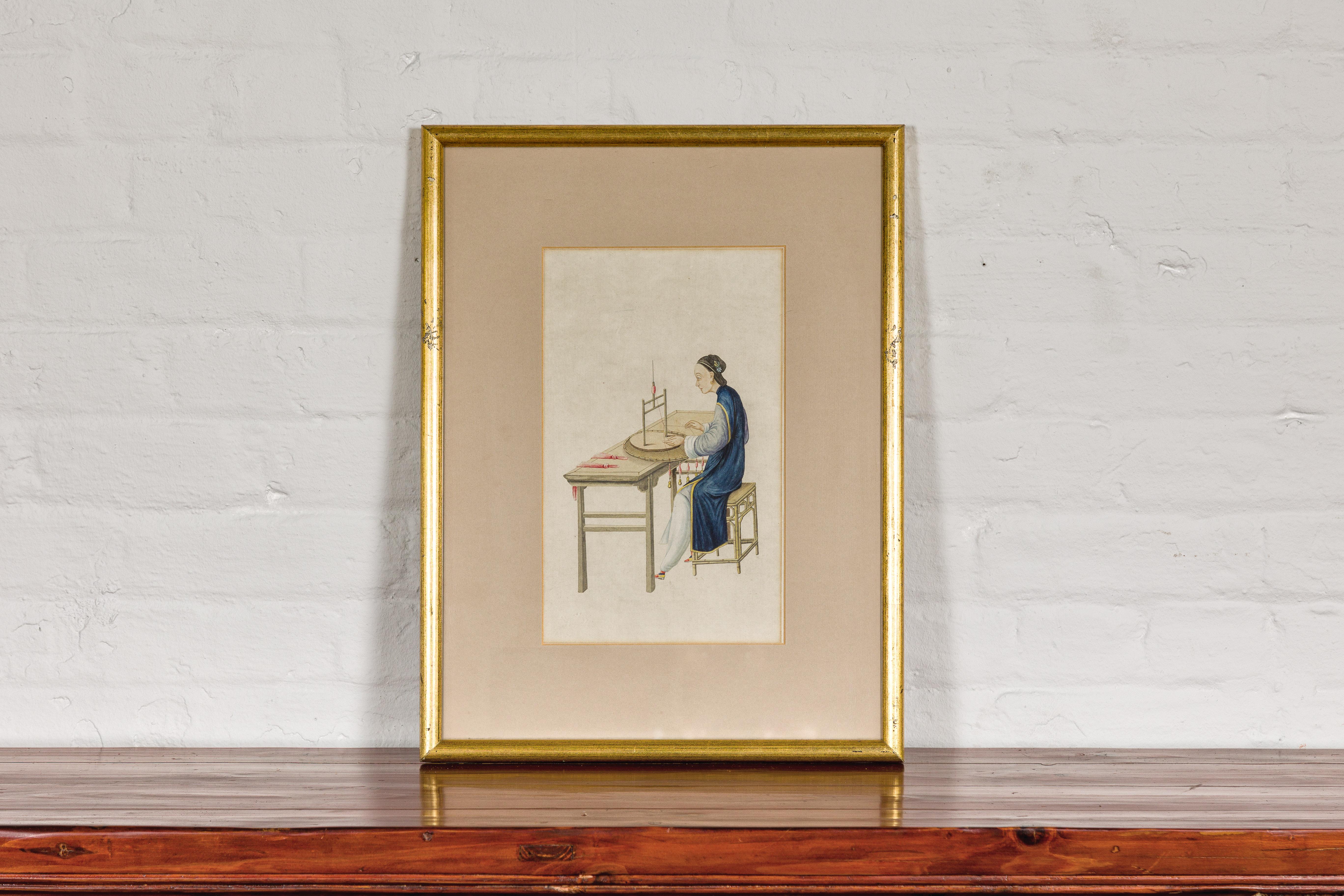 A vintage watercolor on paper depicting a woman in a blue dress threading silk, in gilded wood frame. Discover tranquility and minimalist beauty with this vintage Chinese watercolor, capturing a serene moment of a woman in a blue dress engaged in