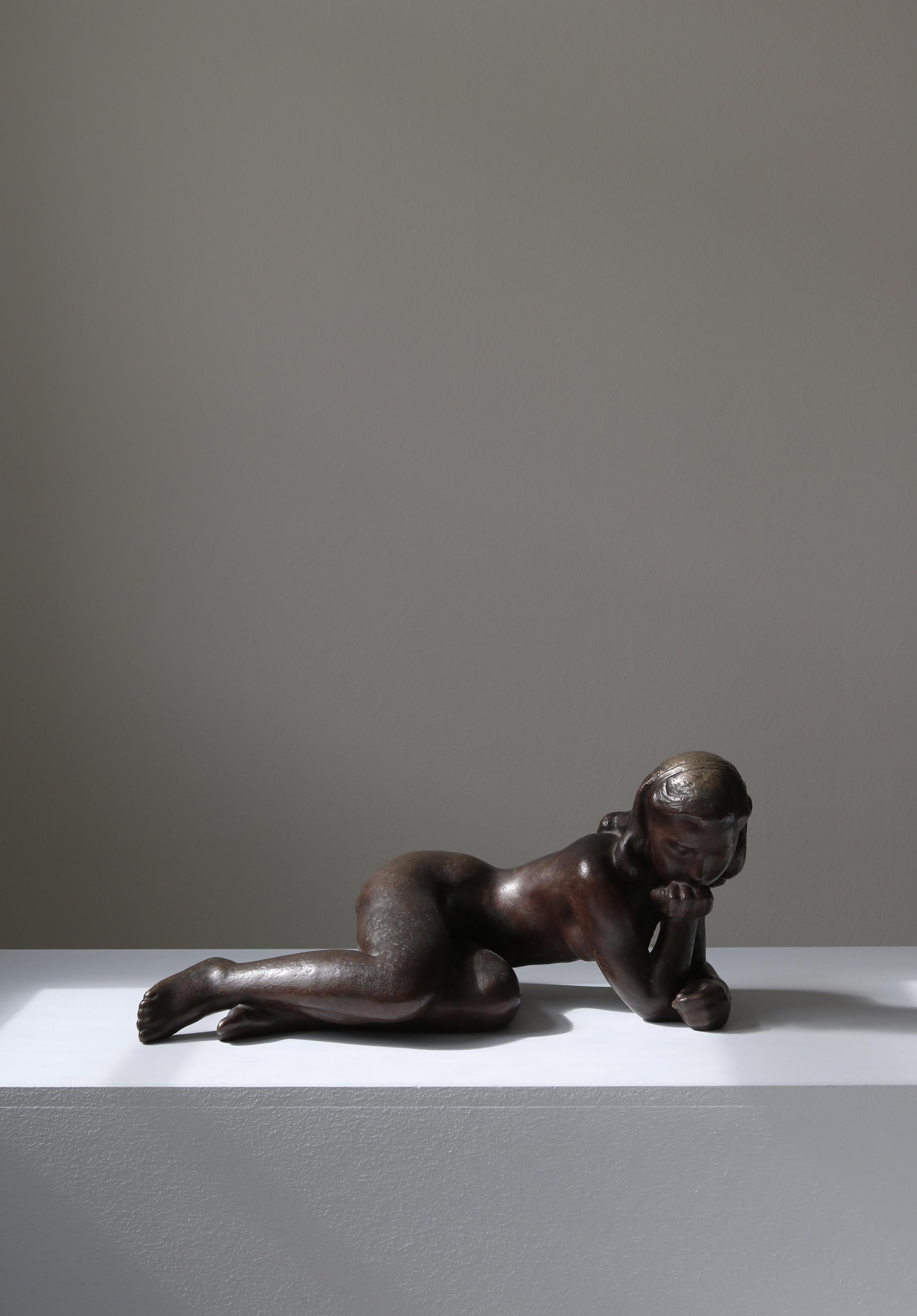 Large cast bronze sculpture by Danish artist Johannes Hansen depicting a young girl lost in thoughts. The sculpture was made in the 1940s at the bronze foundry 