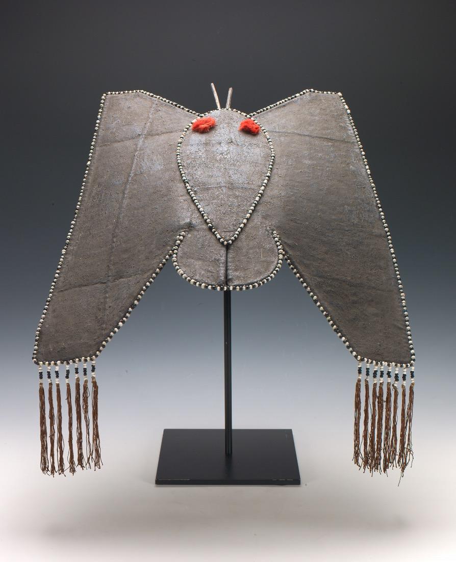 Yao Woman's Hat in Form eines Schmetterlings.
China, Mitte des 20. Jahrhunderts
Leinen auf einem Korbgeflechtrahmen, Holz, Seidenquasten und -fransen, Glasperlen.
22