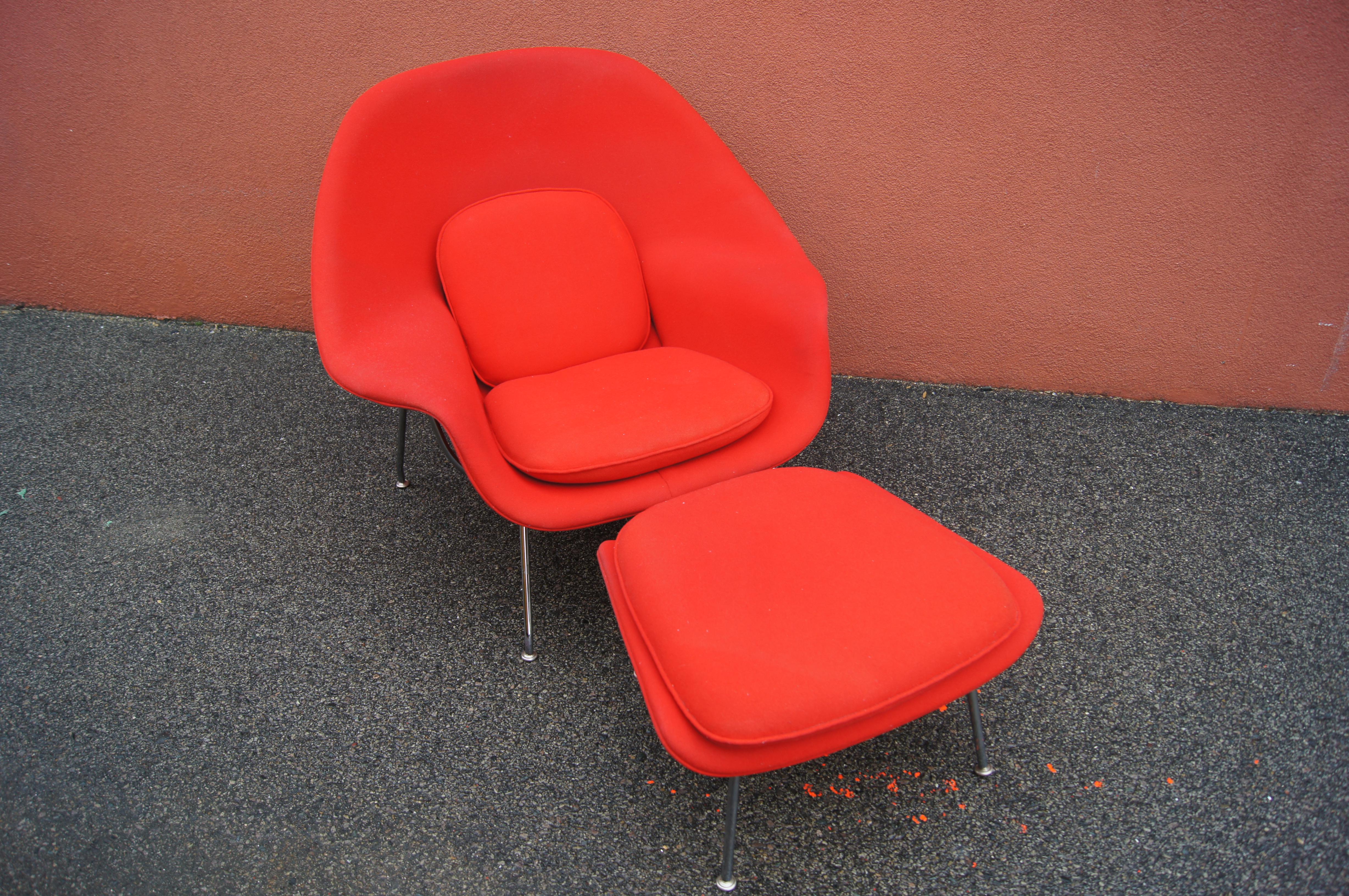Designed by Eero Saarinen for Knoll in 1948, the Womb Chair places a comfortable foam-covered fiberglass shell into a chromed steel rod frame. This Classic womb chair and its matching ottoman are upholstered in the original red-hued Knoll Haze