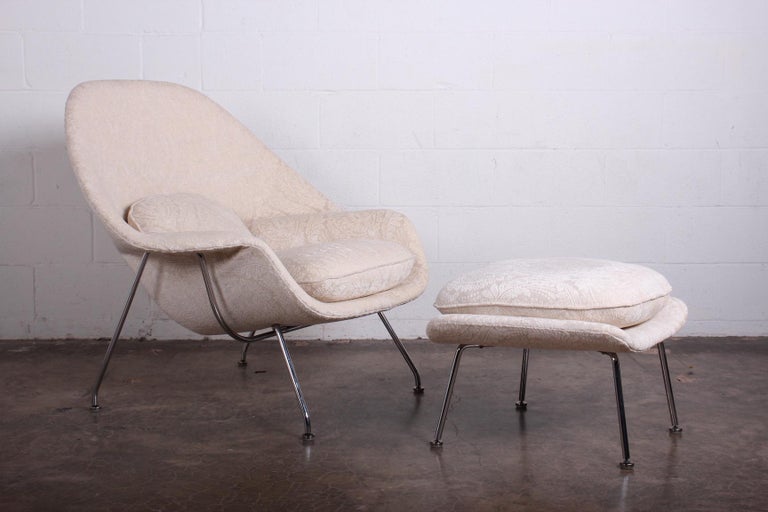A womb chair and ottoman designed by Eero Saarinen for Knoll upholstered in baroque fabric.