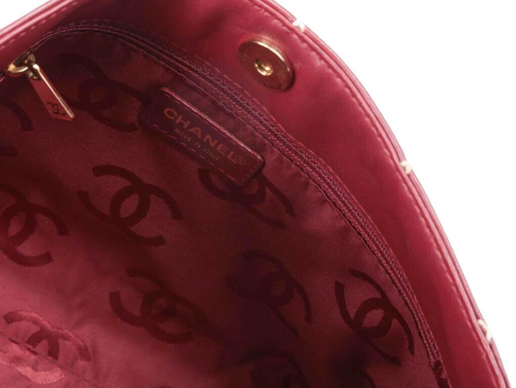 A wonderful Chanel Clutch bag with cross-stitching for sale. Made from dark red calfskin leather and the stitching makes the quilted pattern stand out. A preloved bag for sale in used, excellent condition – do look at photos. The inner zip pull has