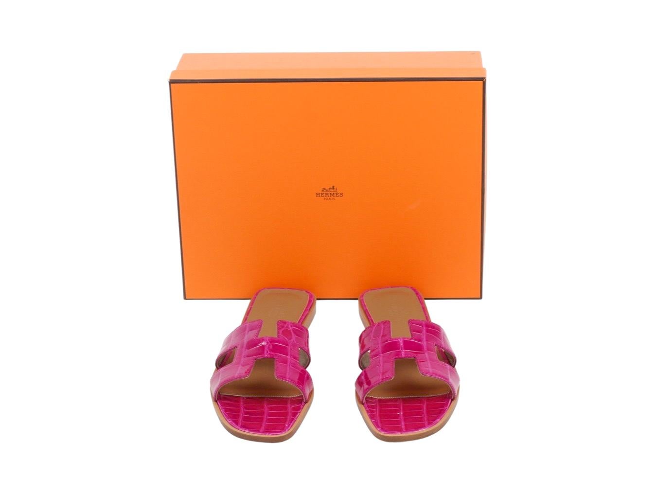 Hermès Oran Sandals crafted in a shiny alligator skin in the shade of Pink Electric. Signature double strap in the form of 'H' shape. Sole and heel are crafted out of stacked wood. Please note that there is light wear on the sole as they have been