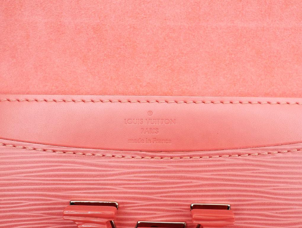 This luxurious bag features an oversize LV logo flip clasp with a removable leather strap. This elegant and modern bag is crafted out of pretty coral epi leather and opens to reveal a spacious interior complete with a zip pocket. This preloved one