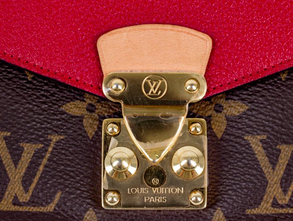 Schöne Geldbörse von Louis Vuitton, die auch als kleine Clutch getragen werden kann. Dieses Pallas Portemonnaie mit Monogram-Muster und rotem Leder ist mit einem Druckknopfverschluss versehen. Eine gebrauchte Brieftasche in sehr gutem Zustand. Die