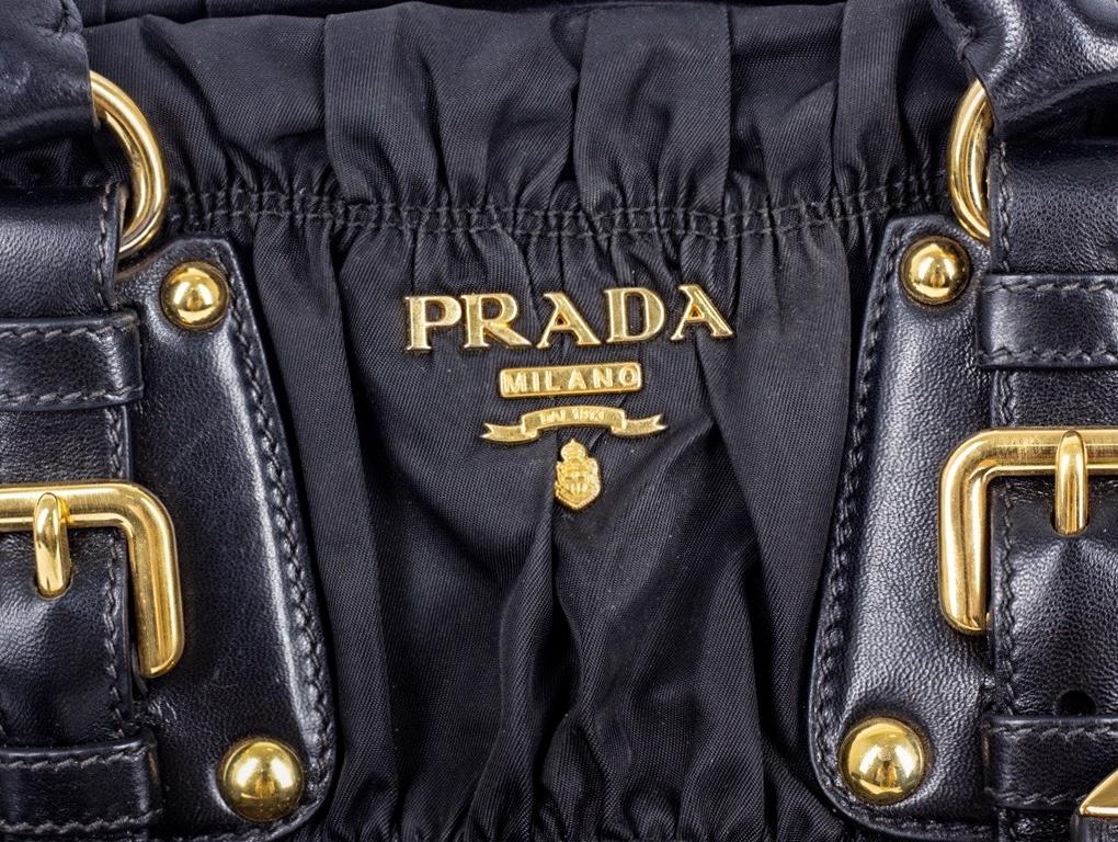 Was für eine hübsche Prada-Tasche das ist. Aus schwarzem Nylon und Leder in gerafftem Design. Tragbar als Tote, Schulter- oder Umhängetasche. Eine gebrauchte Tasche in sehr gutem Zustand, Curling auf dem Leder Gürtel der Schnalle / Kerbe Detail und