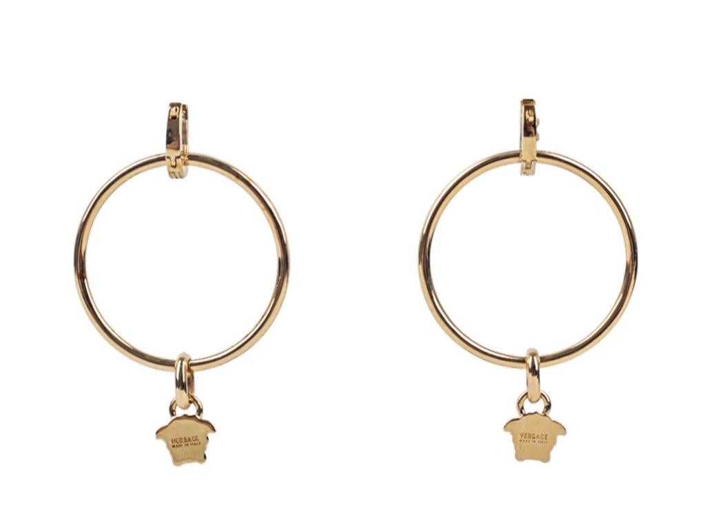 These gold metallic Versace Medusa hoop earrings are for pierced ears, the result of Italian craftsmanship, have been constructed with metal, feature a hoop, clip fastening and signature Medusa pendant and classic engraving. A preloved pair in