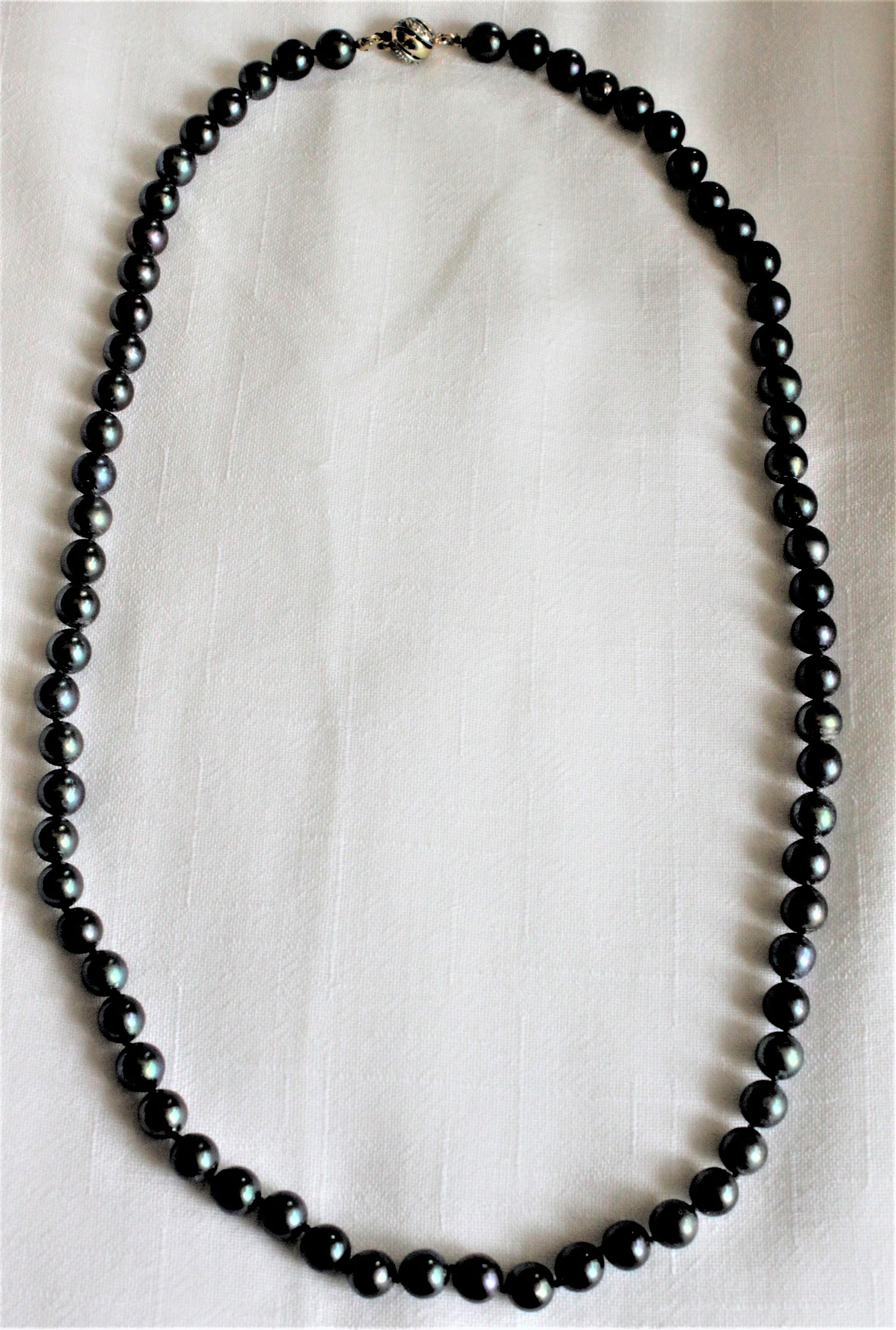 This vintage women's Tahitian graduated black pearl necklace is unmarked with respect to a specific maker, but is marked with European gold marks and believed to originate from Italy. The pearls are presumed to be cultured, but are nicely matched