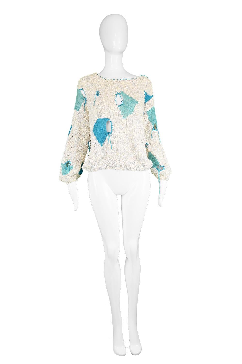 A bold and edgy vintage women's sweater from the 80s in a cream and subtle pastel colored boucle knit fabric with turquoise mohair wool knit with 'holes' finished with laces to create a deconstructed look. A true piece of wearable art, it has a