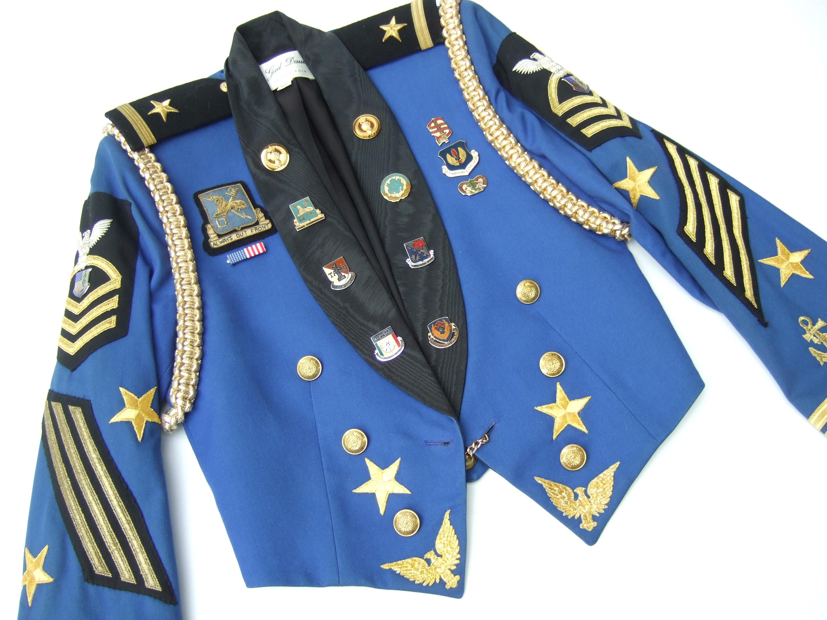 Damen Vintage Militär inspiriert beschnitten Medaillon Jacke entworfen von Gail Dauer Beverly Hills c 1980s 

Die einzigartige Jacke ist mit einer Sammlung von Luftwaffen- und Kriegsabzeichen aus Metall verziert.
Verziert mit applizierten goldenen