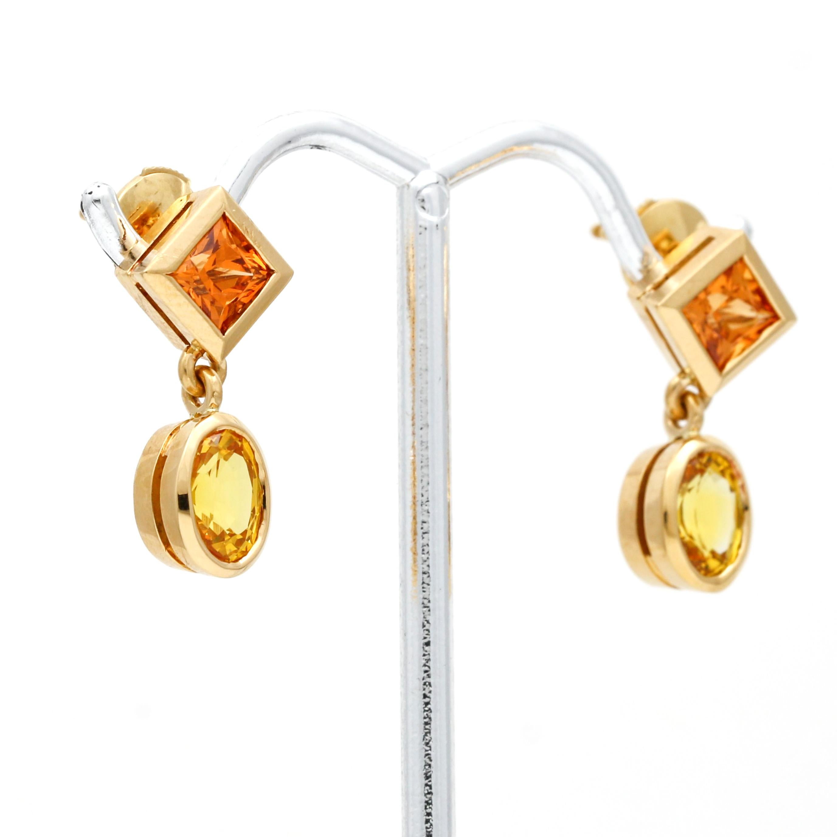 These Women's Madeira Citrine Yellow Sapphire Dangle Earrings in 18k gold are stunning and elegant. Each earring features two beautiful bezel-set gemstones, a princess-cut Madeira citrine, and an oval-cut yellow sapphire that hangs and dangles,