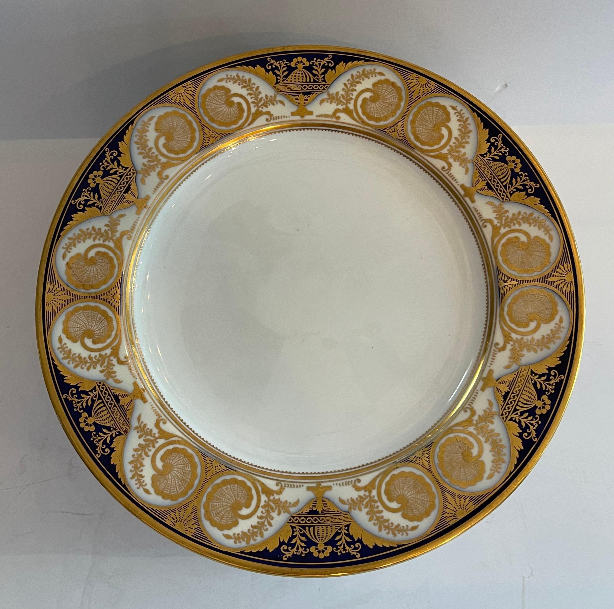A Wonderful set Of 12 Spode Copeland's English fine porcelain dinner service plates with urns set in a cobalt blue & gold border on a white base.