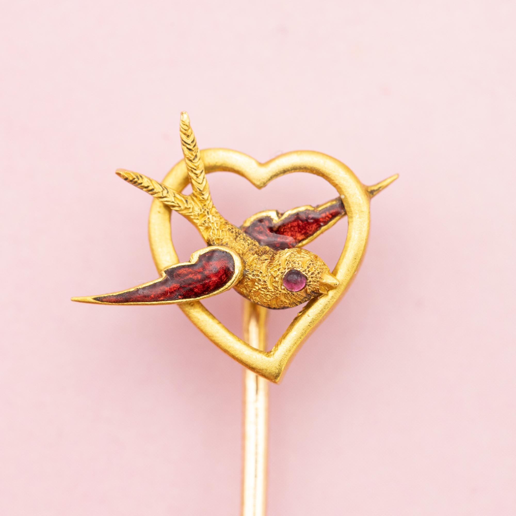 For sale is this wonderful Victorian pin. This lovely antique 18k gold pin is decorated with a small heart with in its centre a Red enamelled swallow. In the Victorian Era swallows represented love and constancy across time and distance, because