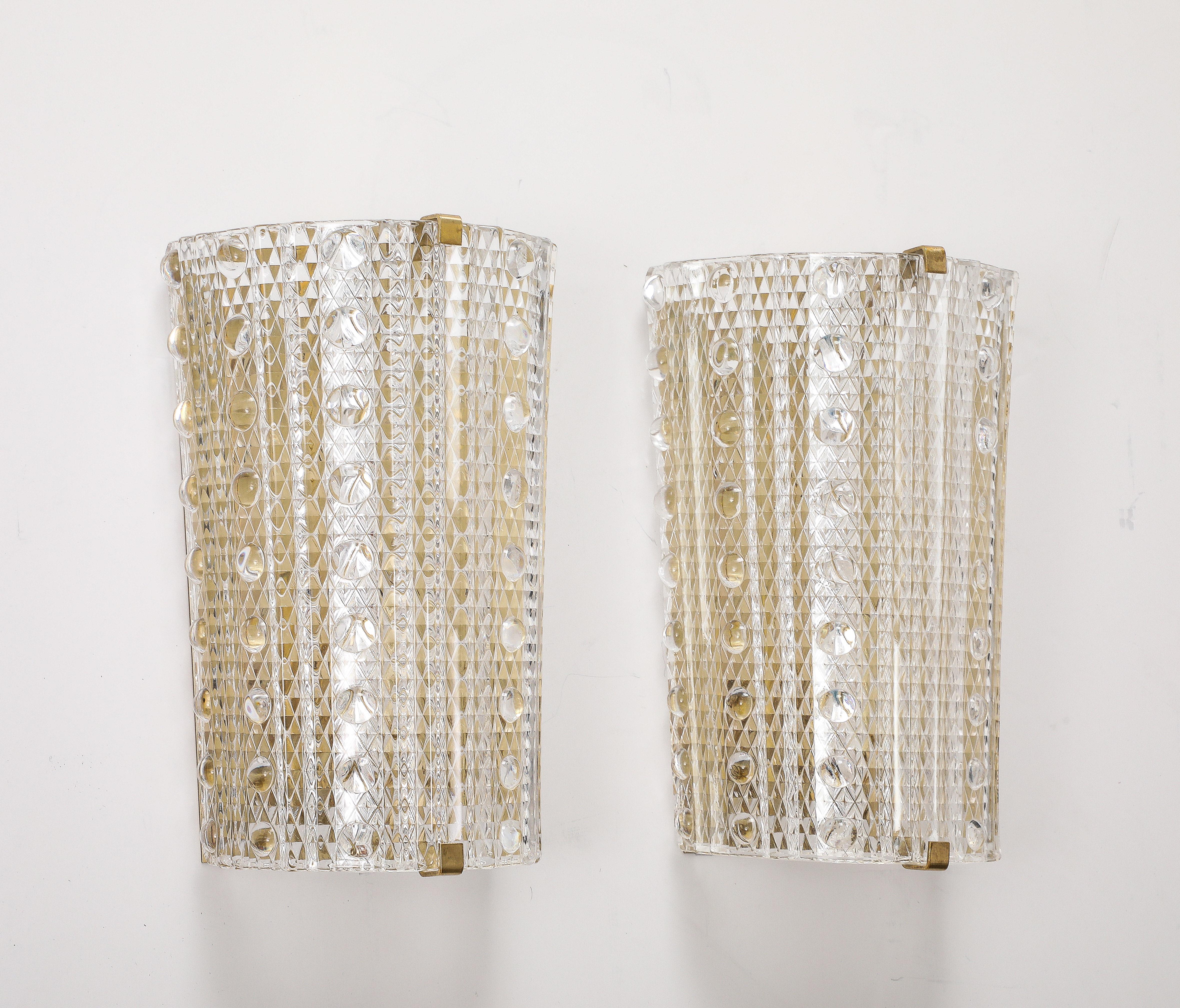 Glamorous pair of large 1960's Glass sconces designed by Carl Fagerlund for Orrefors.
The Demi - lune glass has a wonderful Diamond pattern enhanced with applied half sphere
glass balls.
The Glass  sits on a brass back plate with top and bottom