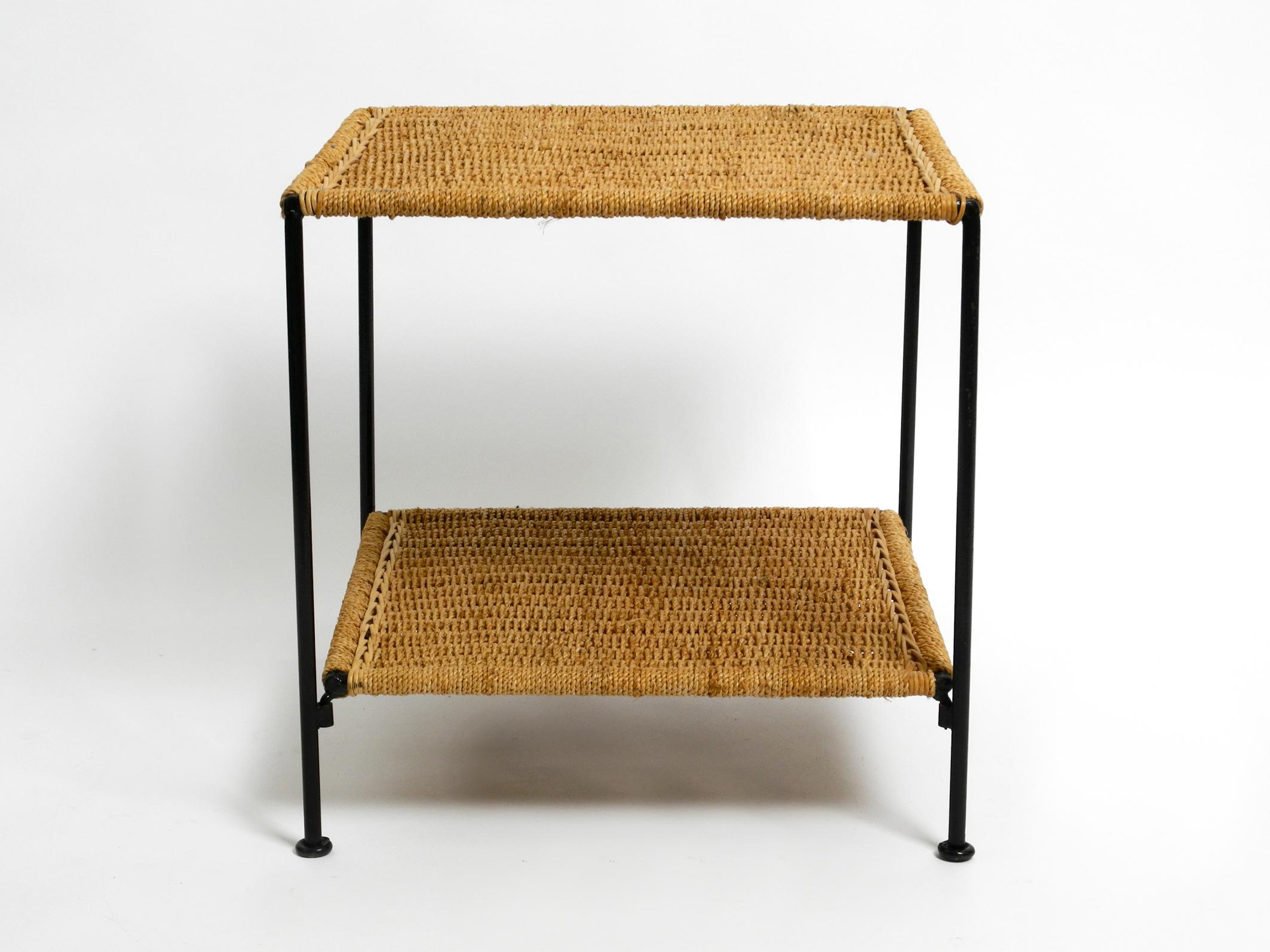 Beautiful 1960s square metal side table with a cord mesh surfaces.
Great minimalistic Italian design.
Frame made entirely of metal in high-gloss black lacquered.
Both shelves are braided with thick cords and with extra rattan braiding on two