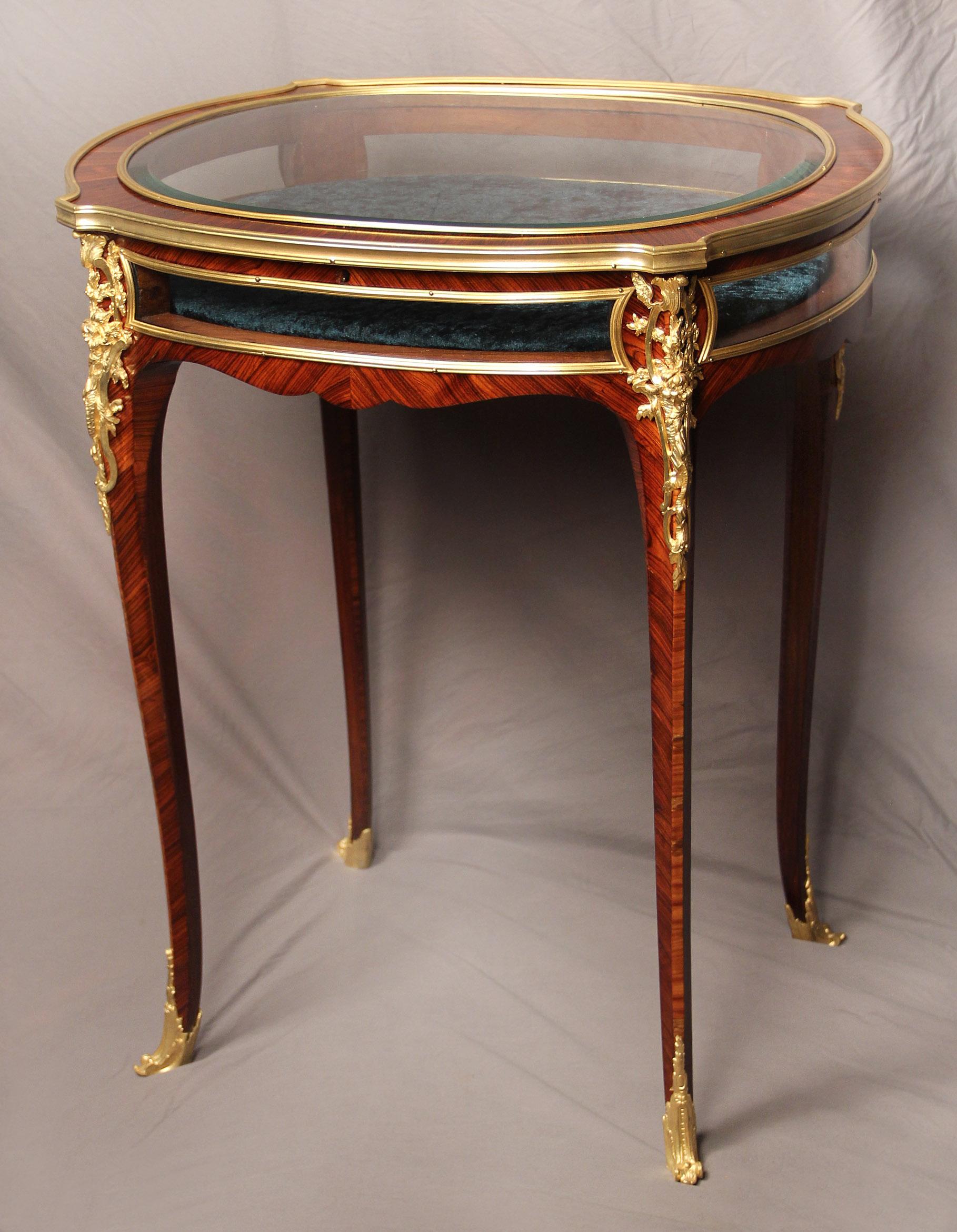 A wonderful late 19th century gilt bronze Mounted Louis XV style Vitrine table by Joseph Zwiener

Joseph Zwiener

The oval shaped table with a beveled glass top encircled by a bronze frieze, above four side glass panels, the canted angles set