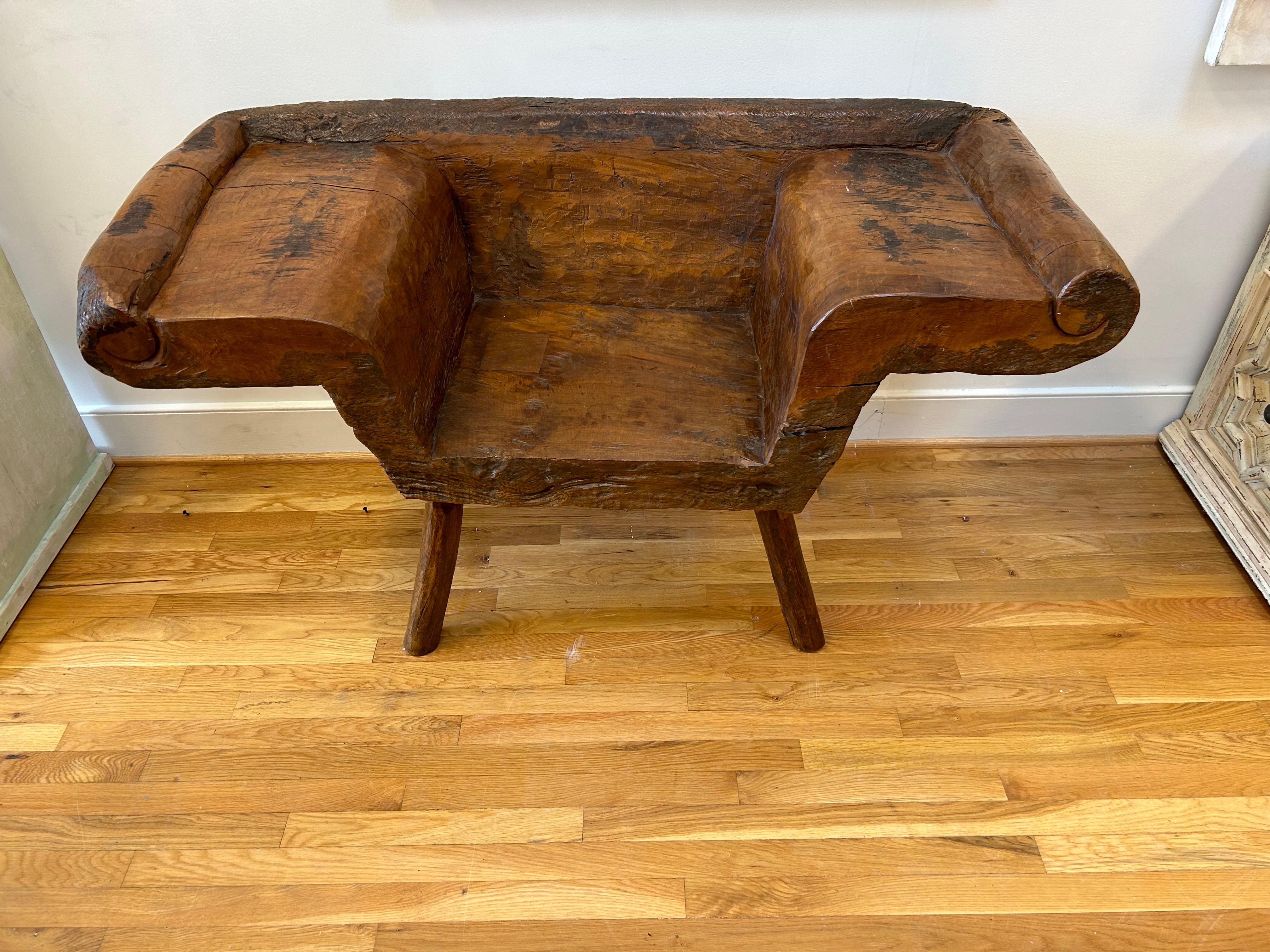 Merveilleux banc indonésien du 19ème siècle. Sculptée dans une seule pièce de racine de teck javanais, elle présente des proportions généreuses et un décor sculpté sur des pieds rustiques, le tout conservant une belle finition d'origine avec une