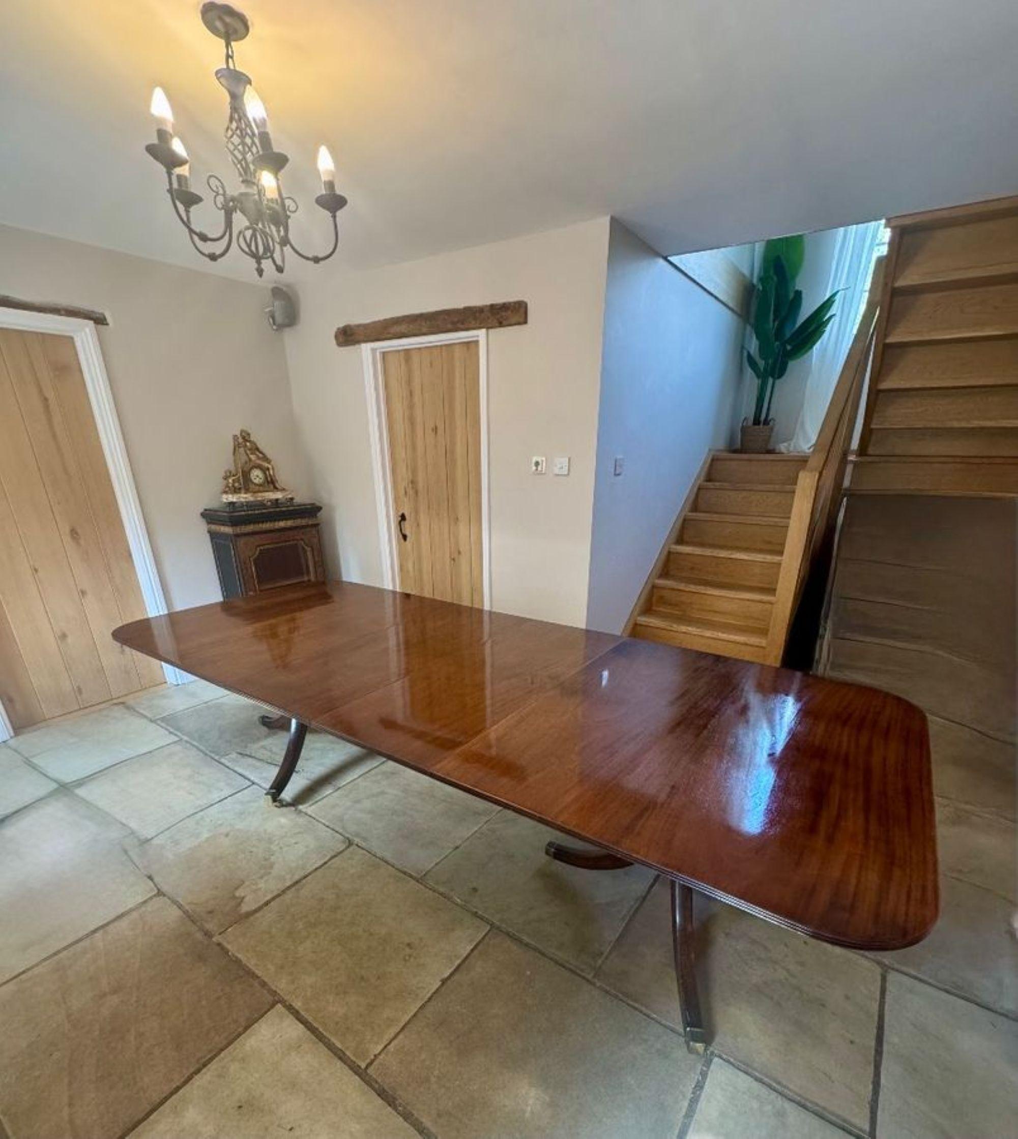 Wonderful antique Edwardian quality figured mahogany 12 seater two pilar dining table, having a quality figured mahogany top with a reeded edge and the two original extra leaves supported on two turned pedestal columns standing on three sabre legs