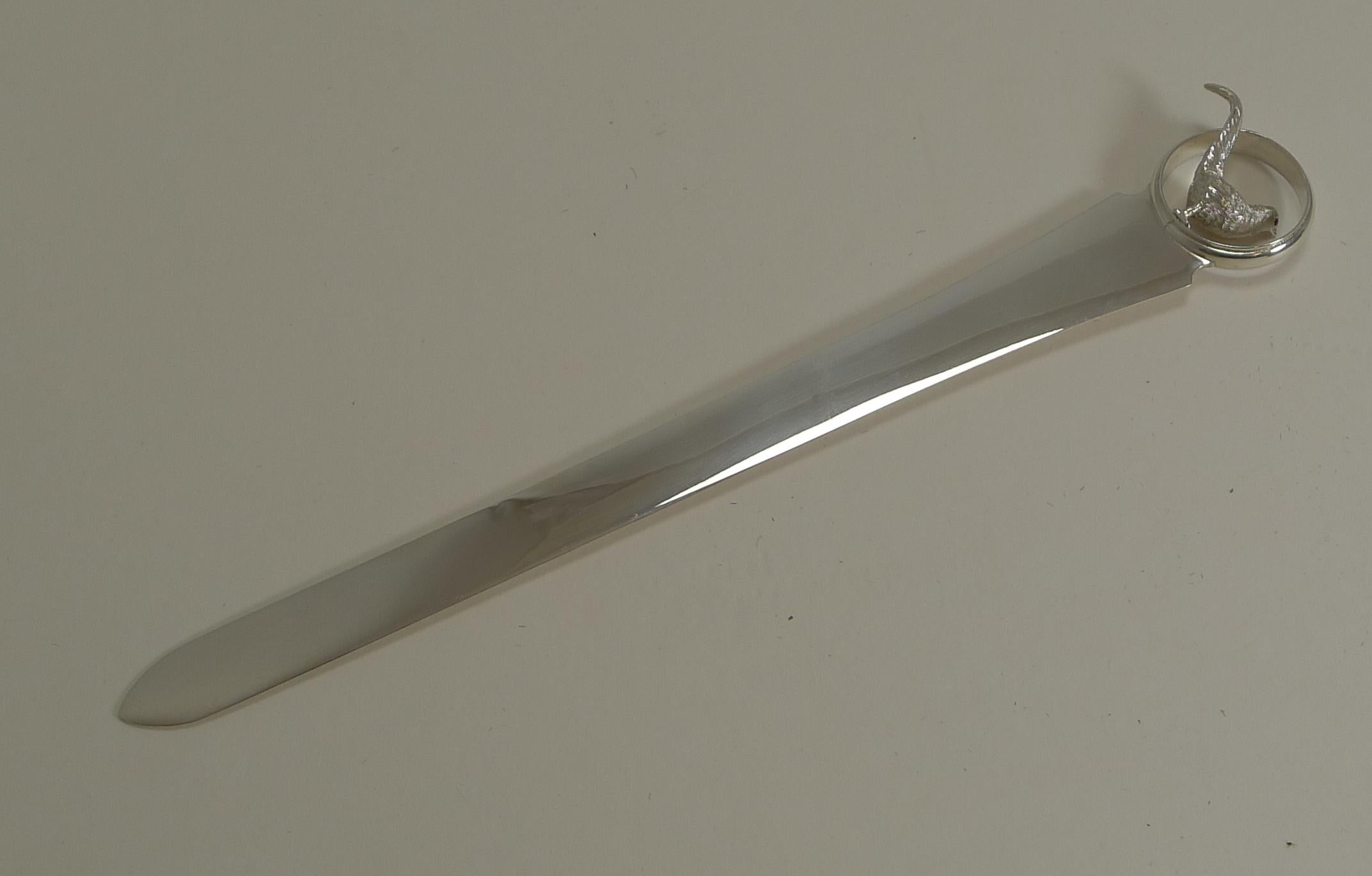 A handsome Edwardian figural letter opener made from a good gauge of English sterling hallmarked for London, 1908.

Of course what makes this a scarce and outstanding example is the circular terminal sporting a wonderful Pheasant with two glass