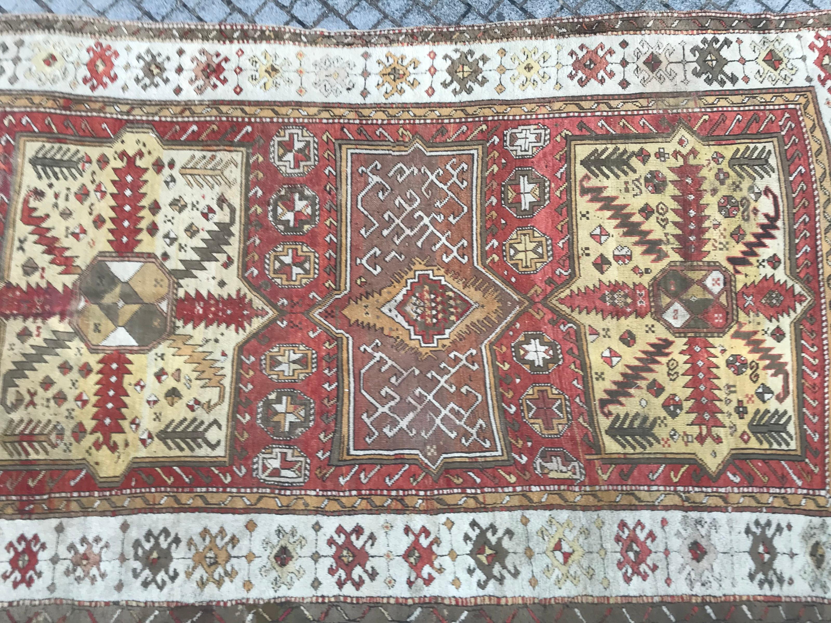 Beautiful antique Turkish rug with a geometrical Kazak design and natural colors with orange, red, yellow and green, very decorative, entirely hand knotted with wool velvet on wool foundation.