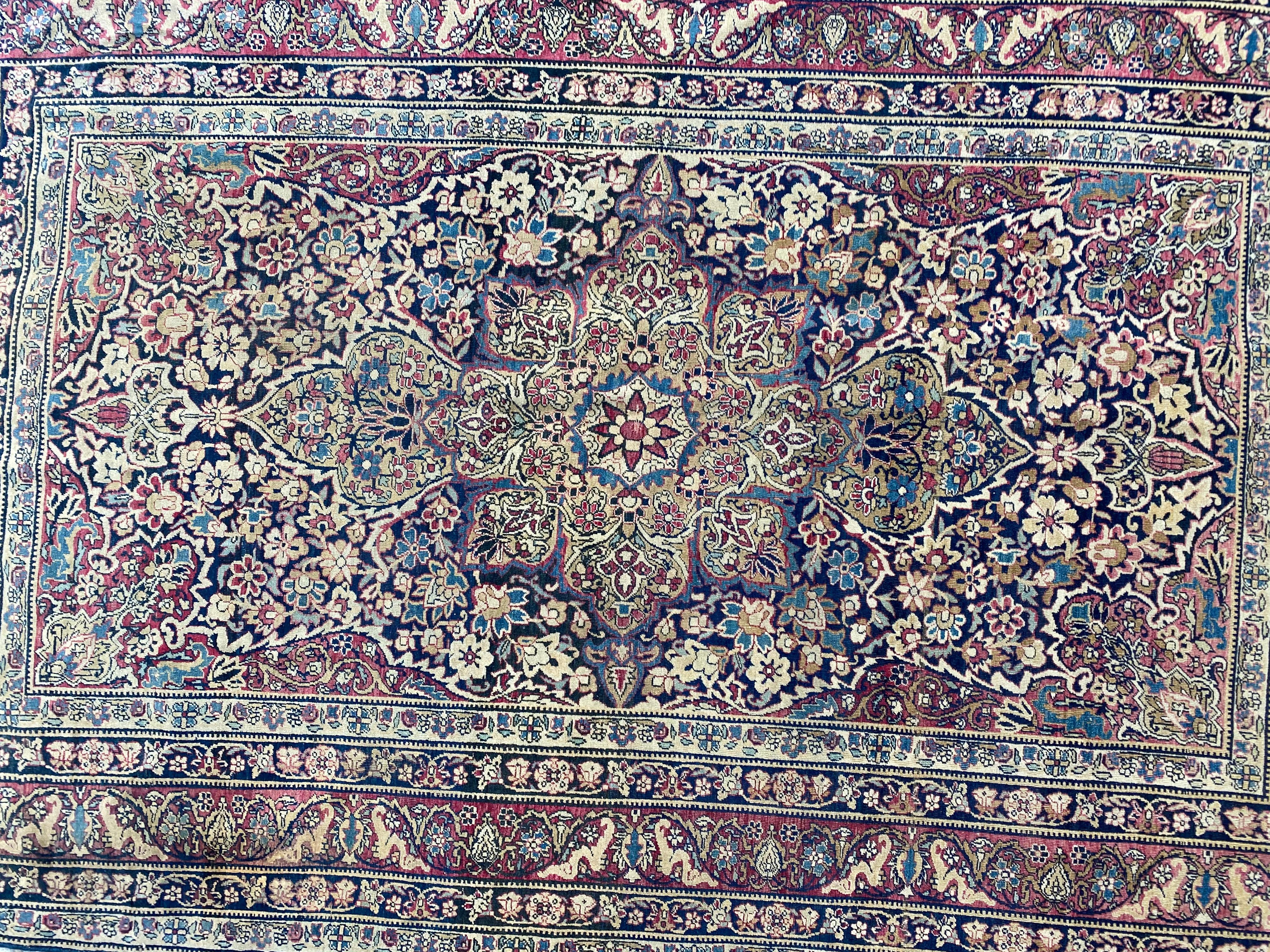 Exquis tapis de la fin du 19e siècle présentant un captivant motif floral et un médaillon central. De magnifiques couleurs naturelles, dont le bleu foncé, le jaune, le bleu et le rouge, méticuleusement nouées à la main avec du velours de laine sur