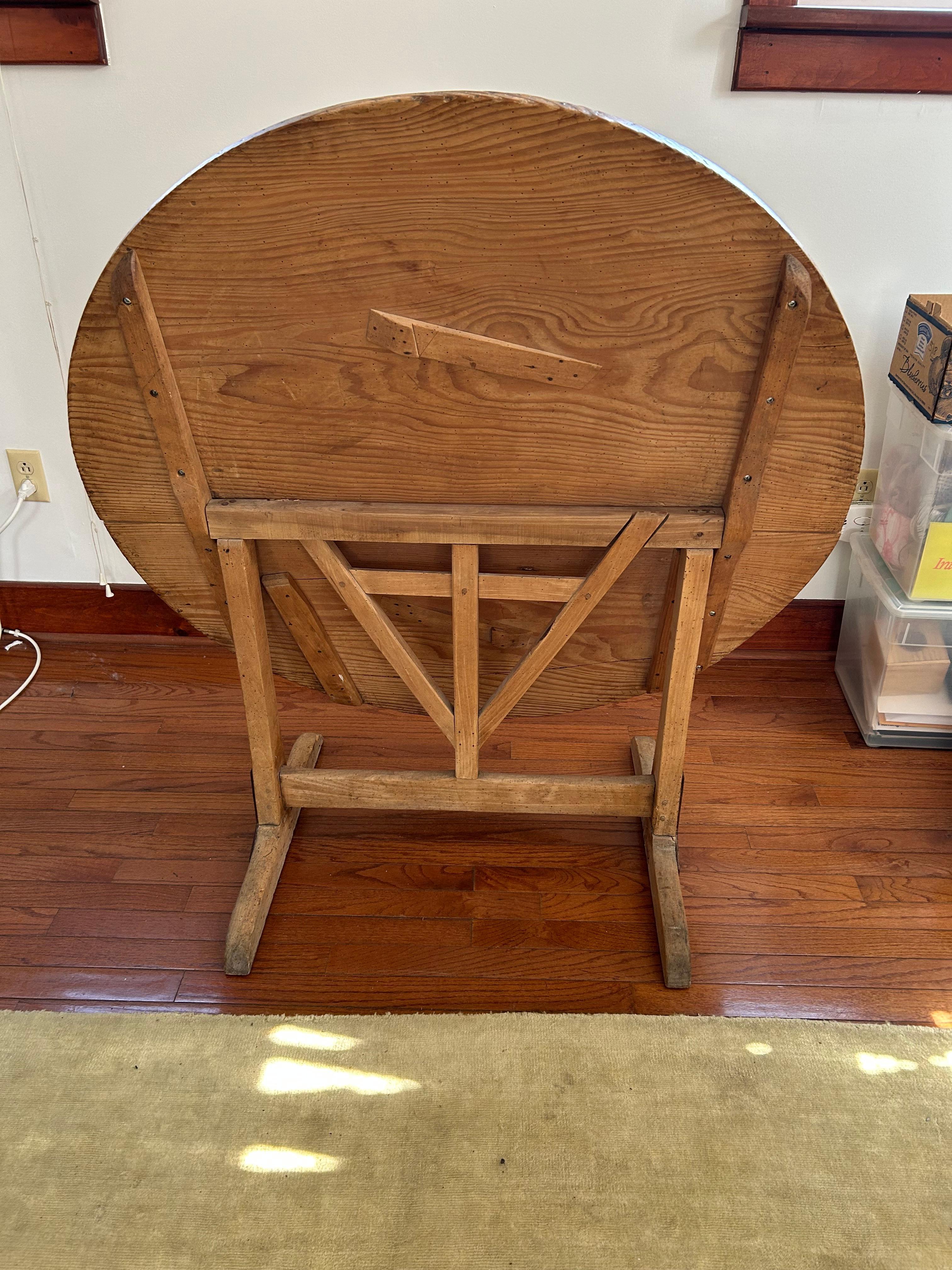 Character rich old distressed natural oak wine tasting table, almost round top and bases with metal reinforced legs.  Can fold upright and when folded upright 45” h 42” w
Low for a dining table but great as a side table or console.

(Painter)
