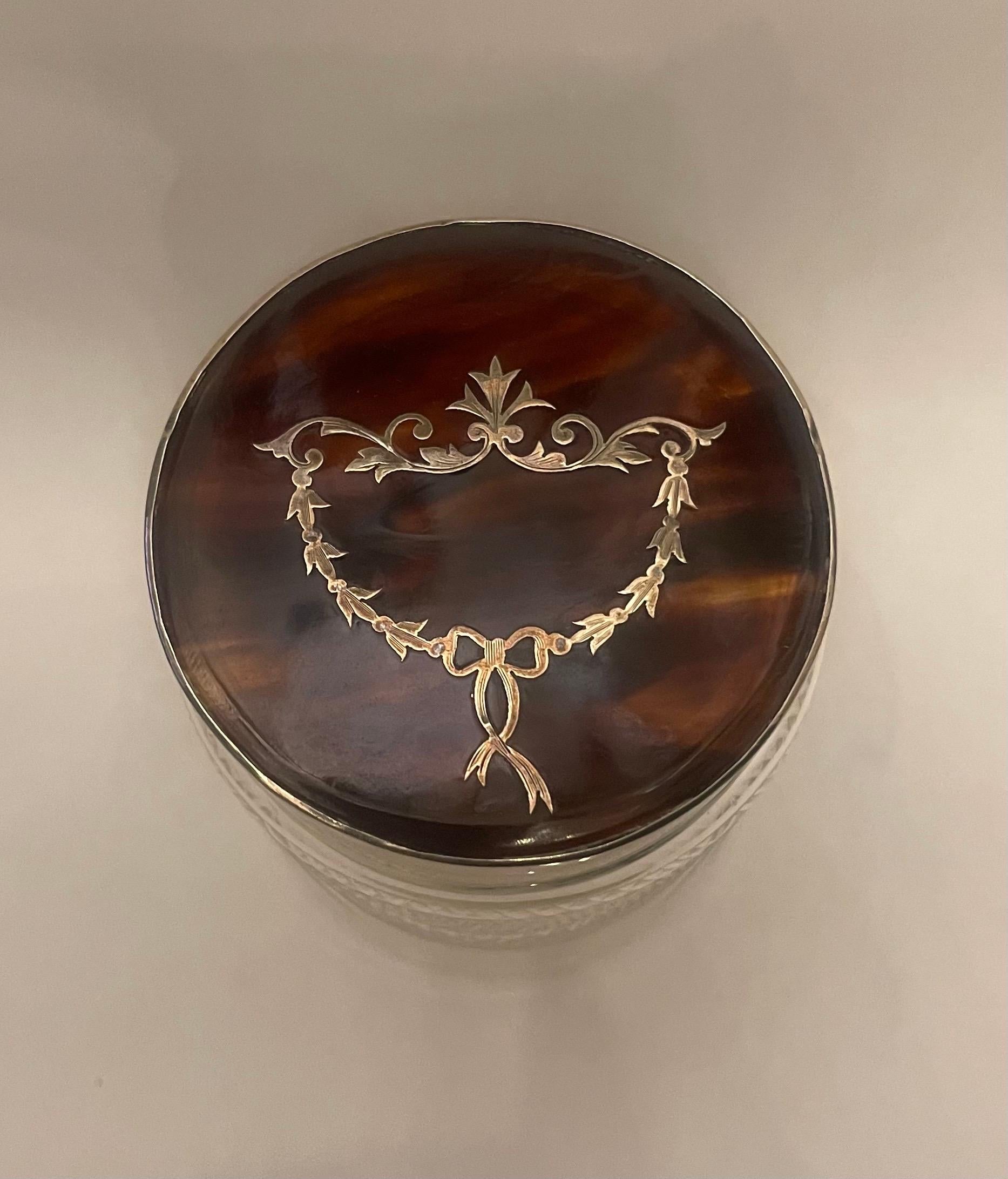 A Wonderful Sterling Silver And Tortoise Shell Vanity Powder / Trinket Box Or Jar. The Sterling Silver Top Having A Tortoise Shell Pique Inlaid Removable Lid With English Silver Marks. The Clear Cut Crystal Bottle Has Been Delicately Engraved.