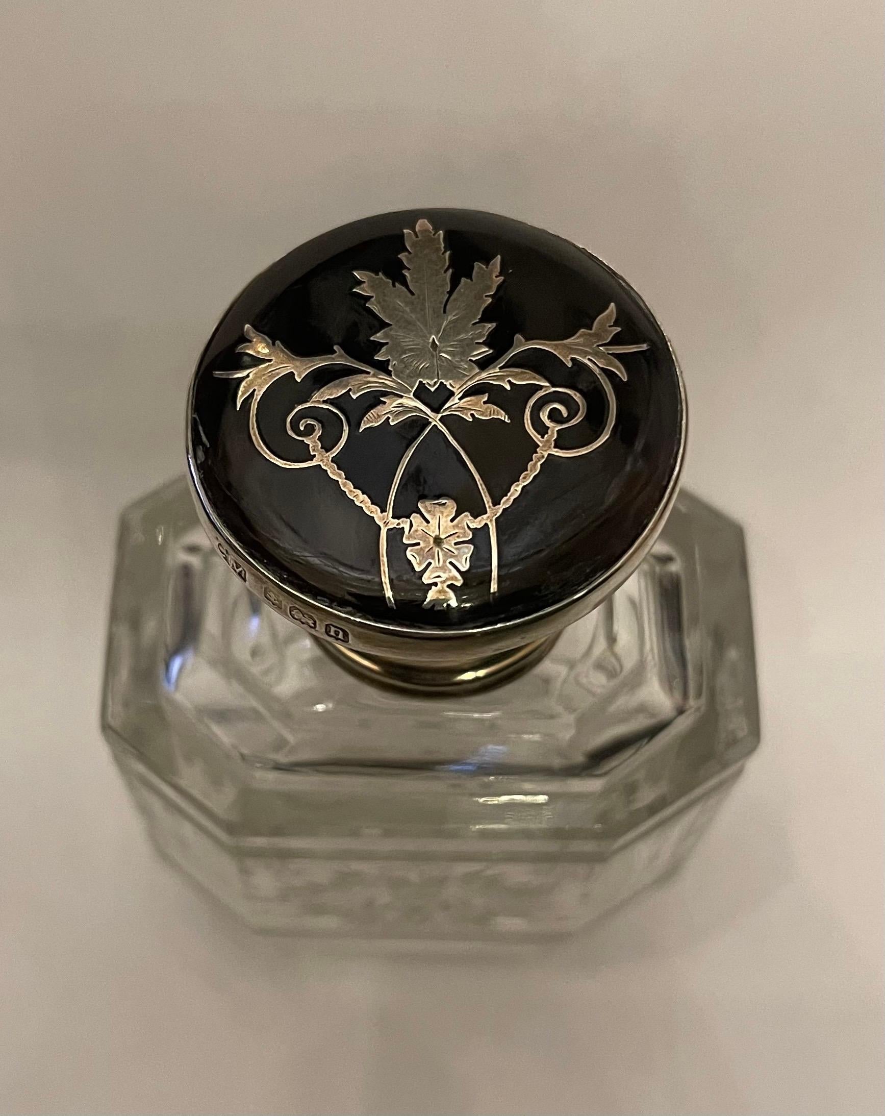 A Wonderful Sterling Silver And Tortoise Shell Perfume Bottle With A Hinged Silver And Tortoise Shell Pique Inlaid Lid. The Clear Cut Crystal Bottle Has Been Delicately Engraved And Has The Original Glass Stopper