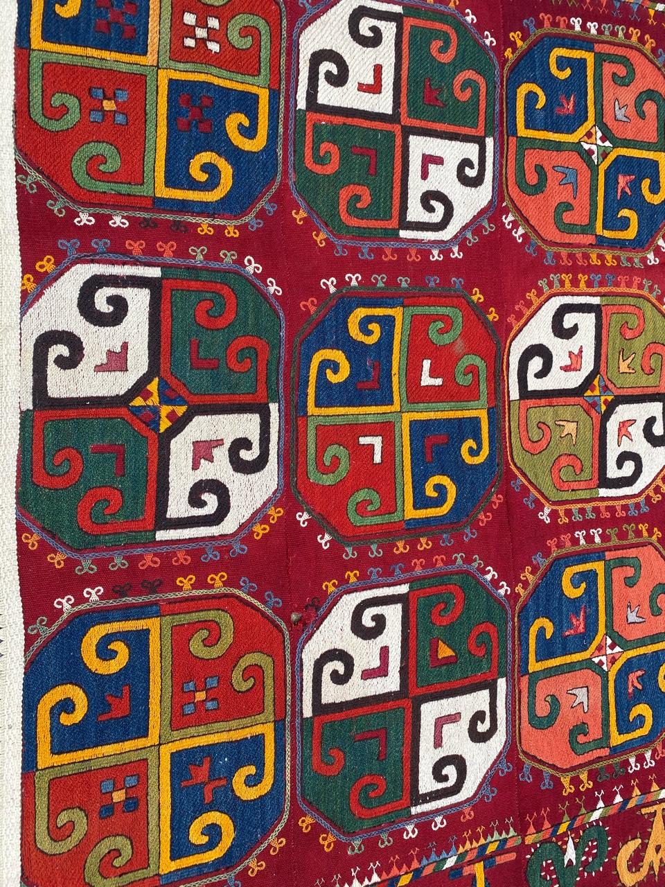 Discover the exquisite craftsmanship of a stunning early 20th-century Uzbek embroidery. Adorned with a captivating Bokhara design, this piece boasts beautiful geometrical patterns and vibrant natural colors. Meticulously handwoven and embroidered