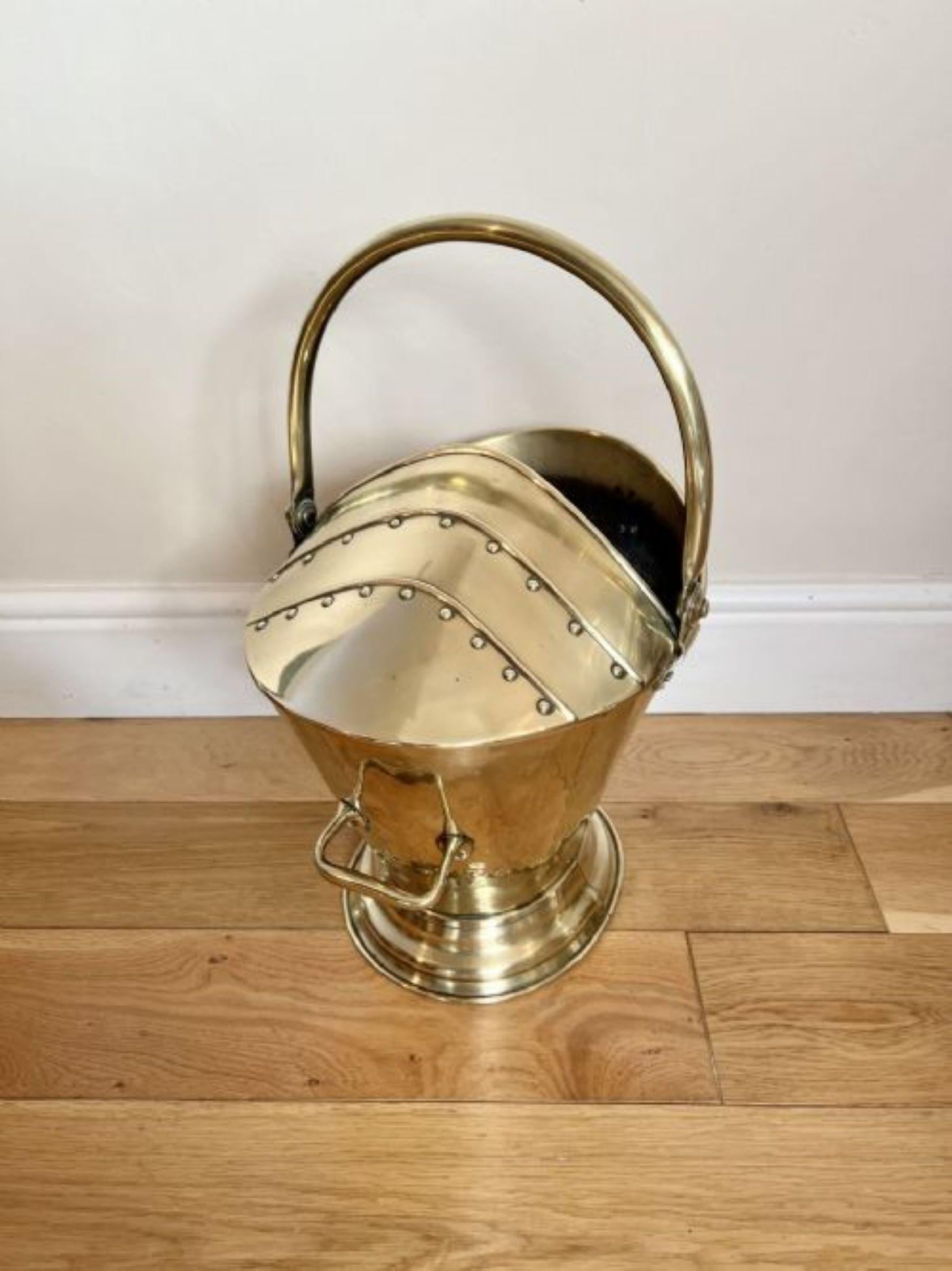 Wonderful antique Victorian quality brass coal scuttle having a quality antique victorian brass coal scuttle with a swing handle to the top, a handle to the back and a half covered top with brass rivet decoration, standing on a circular stepped base