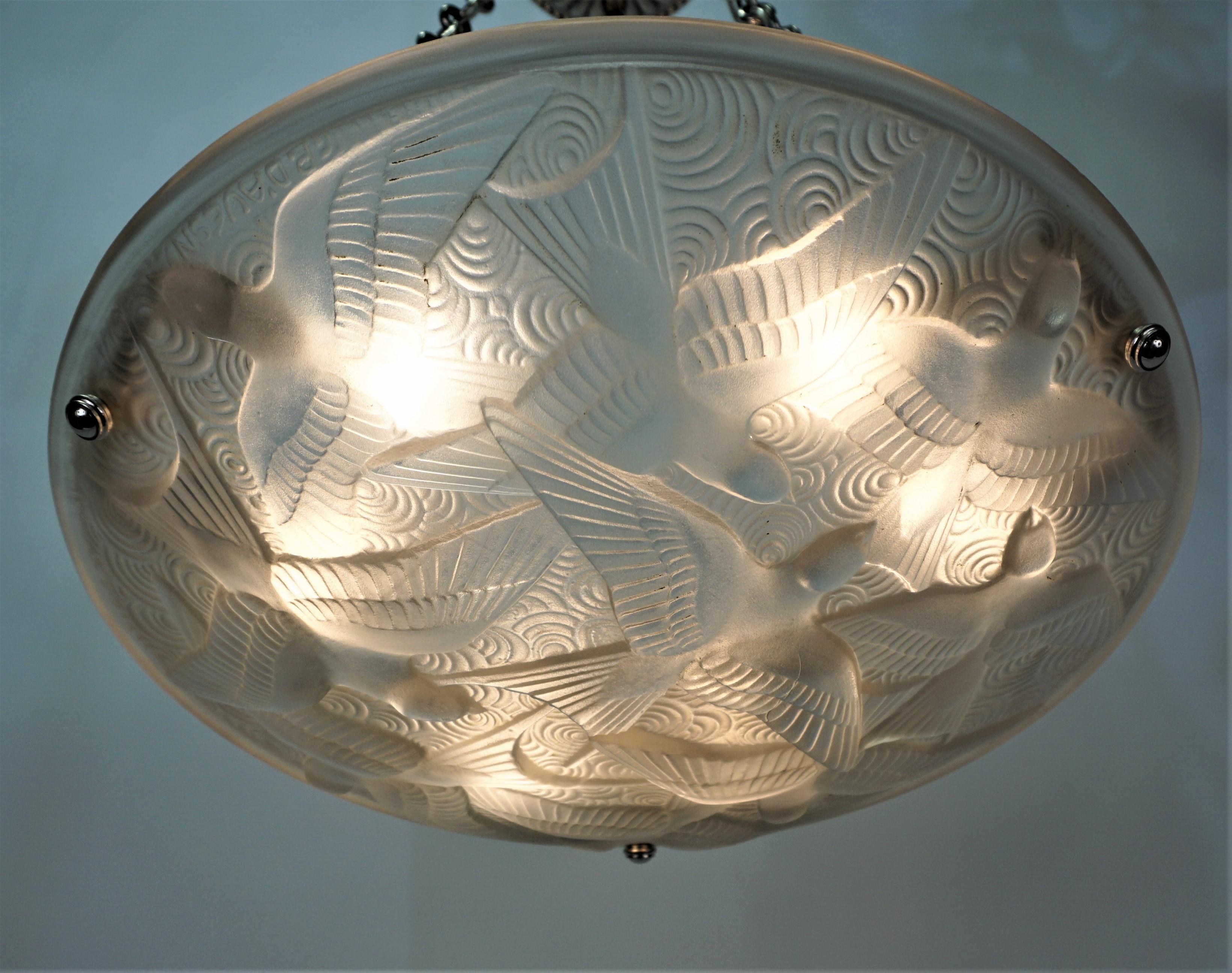 Amazing glass shade with flying swallows and nickel on bronze chain and hardware.
Pierre D'Avesn designed beautiful glass for Lalique and Daum.
His pieces are well sought for.
