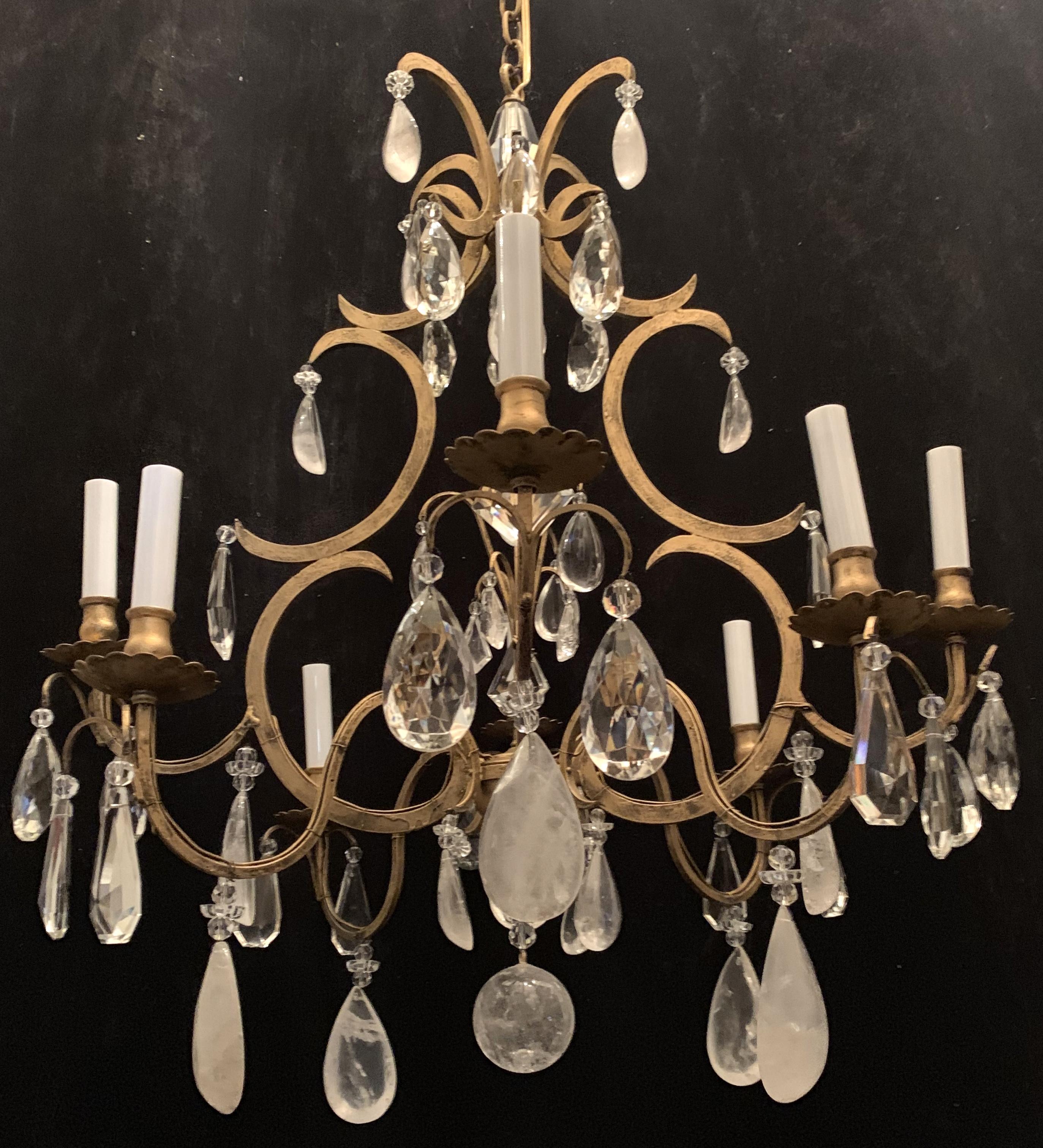 A wonderful Baguès style French rock crystal and flower crystals throughout with a gold gilt patina, over an eight-light iron bird cage form chandelier.
Completely rewired and ready to install with chain and canopy.