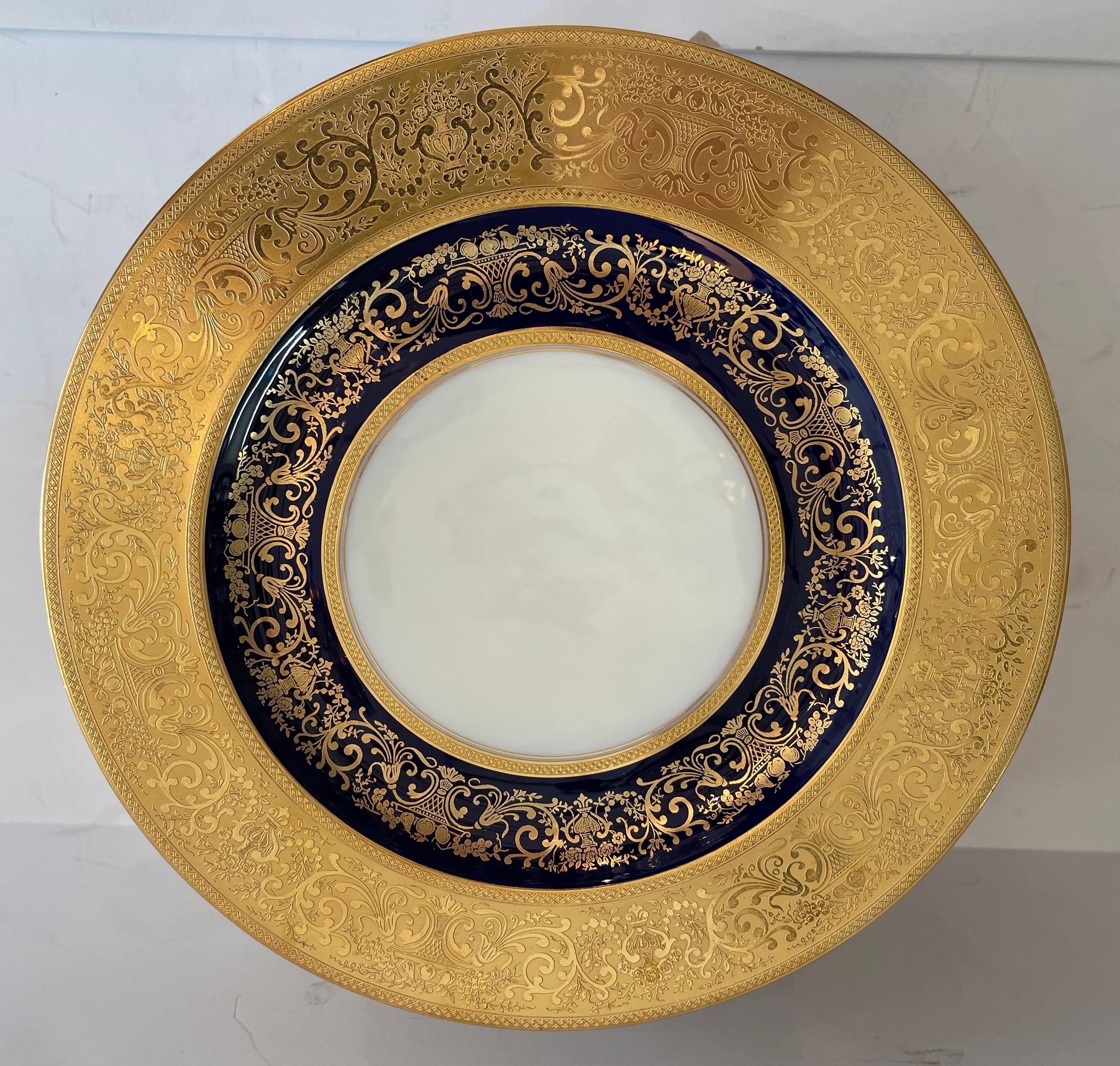 A Wonderful Black Knight set of 12 service dinner plates with raised encrusted gold over a cobalt blue interior band.