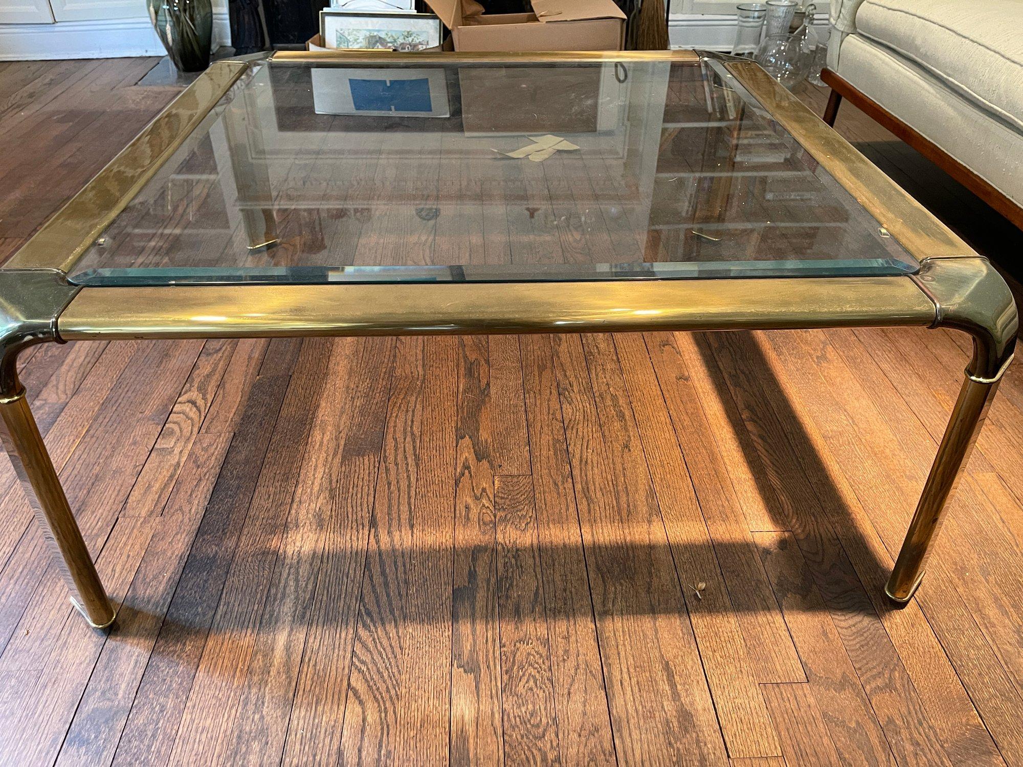 Merveilleuse table basse carrée en laiton John Widdicomb. Nous adorons le design moderne et épuré avec le plateau en verre biseauté. Cette pièce mesure 17.25