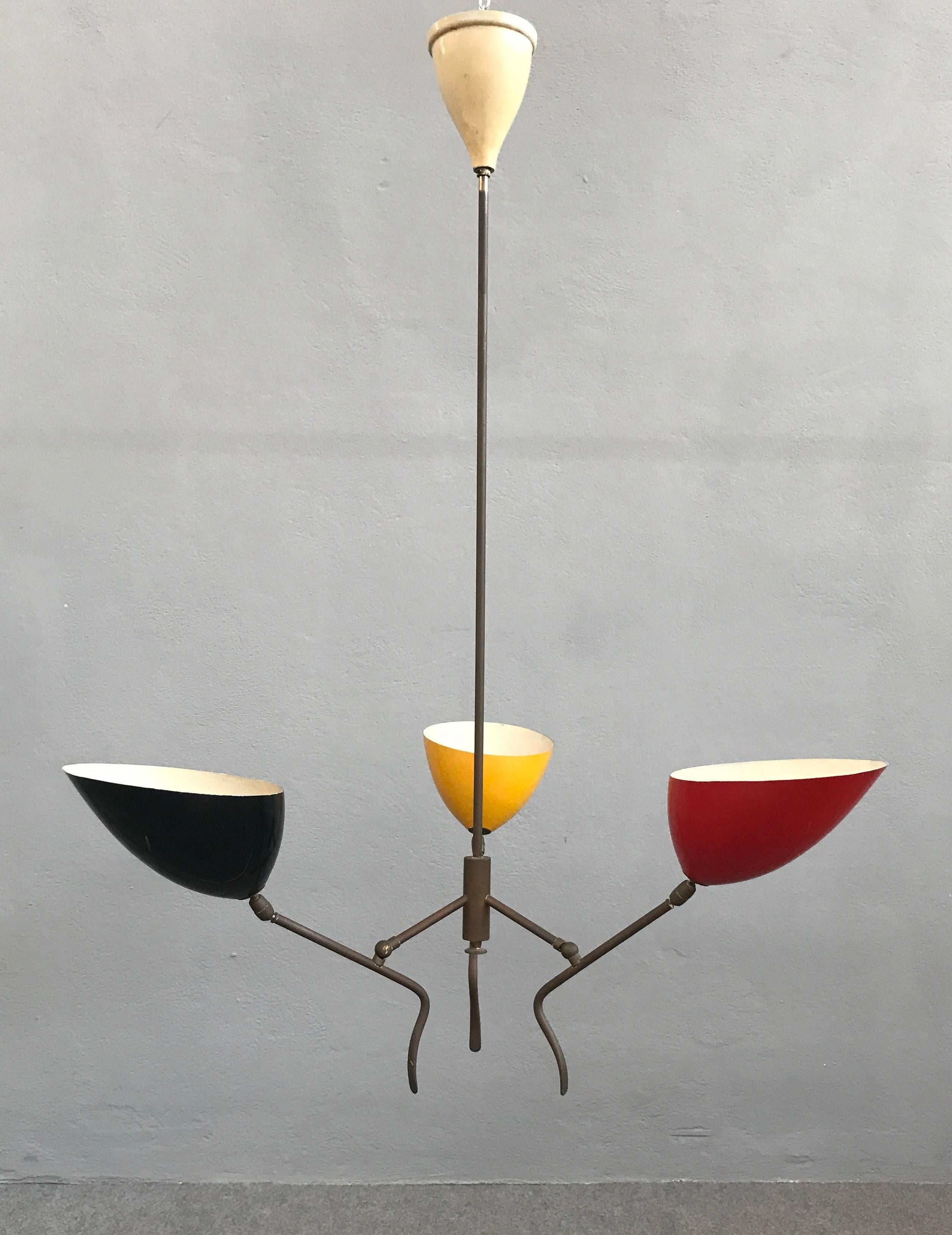 Black, yellow and red metal lacquered cones with articulating brass arms. Lumi Milano, 1950.