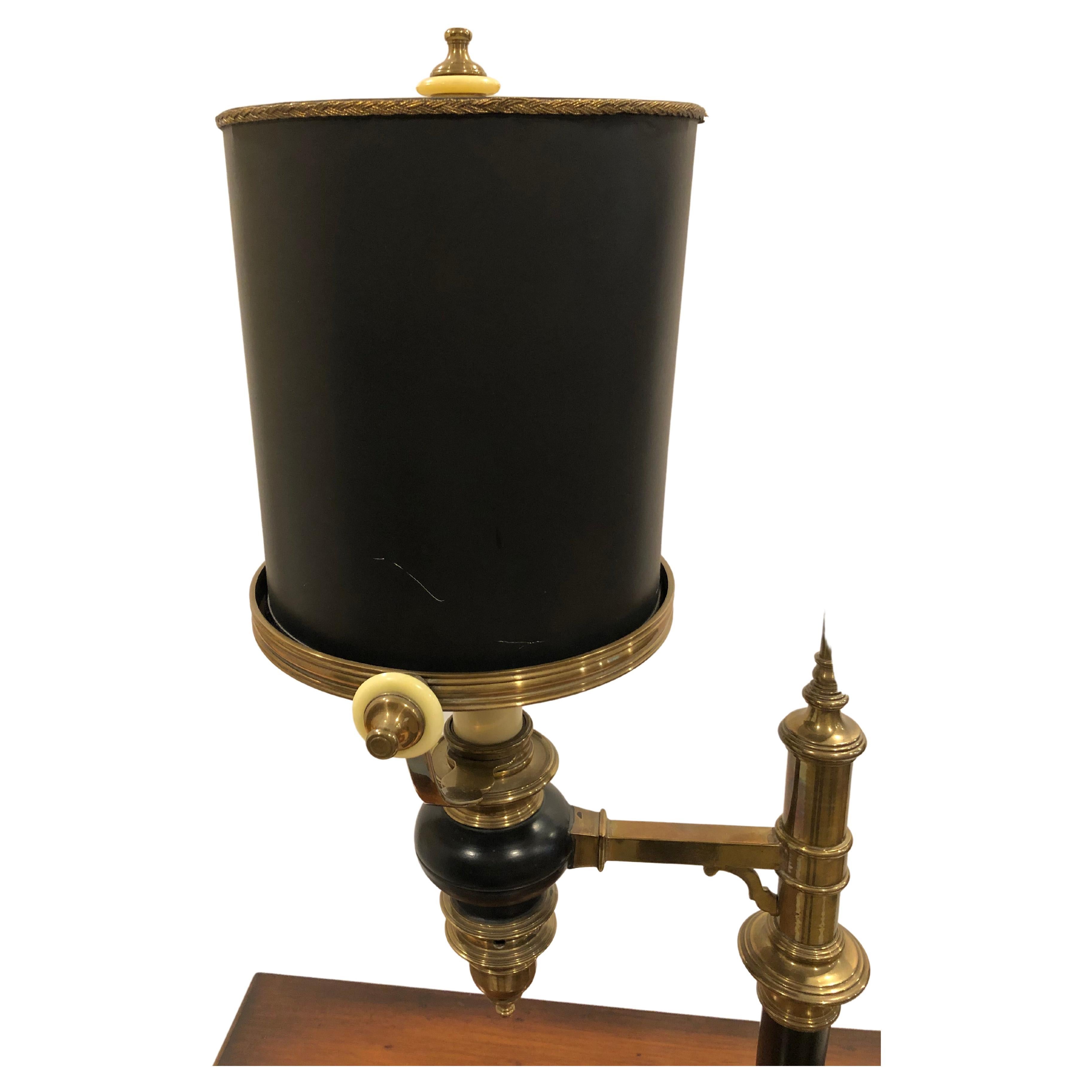 Wonderful character rich desk or table lamp by Chapman having a mix of brass and black painted metal, enamel white knobs and a fabulous cylindrical shaped shade.