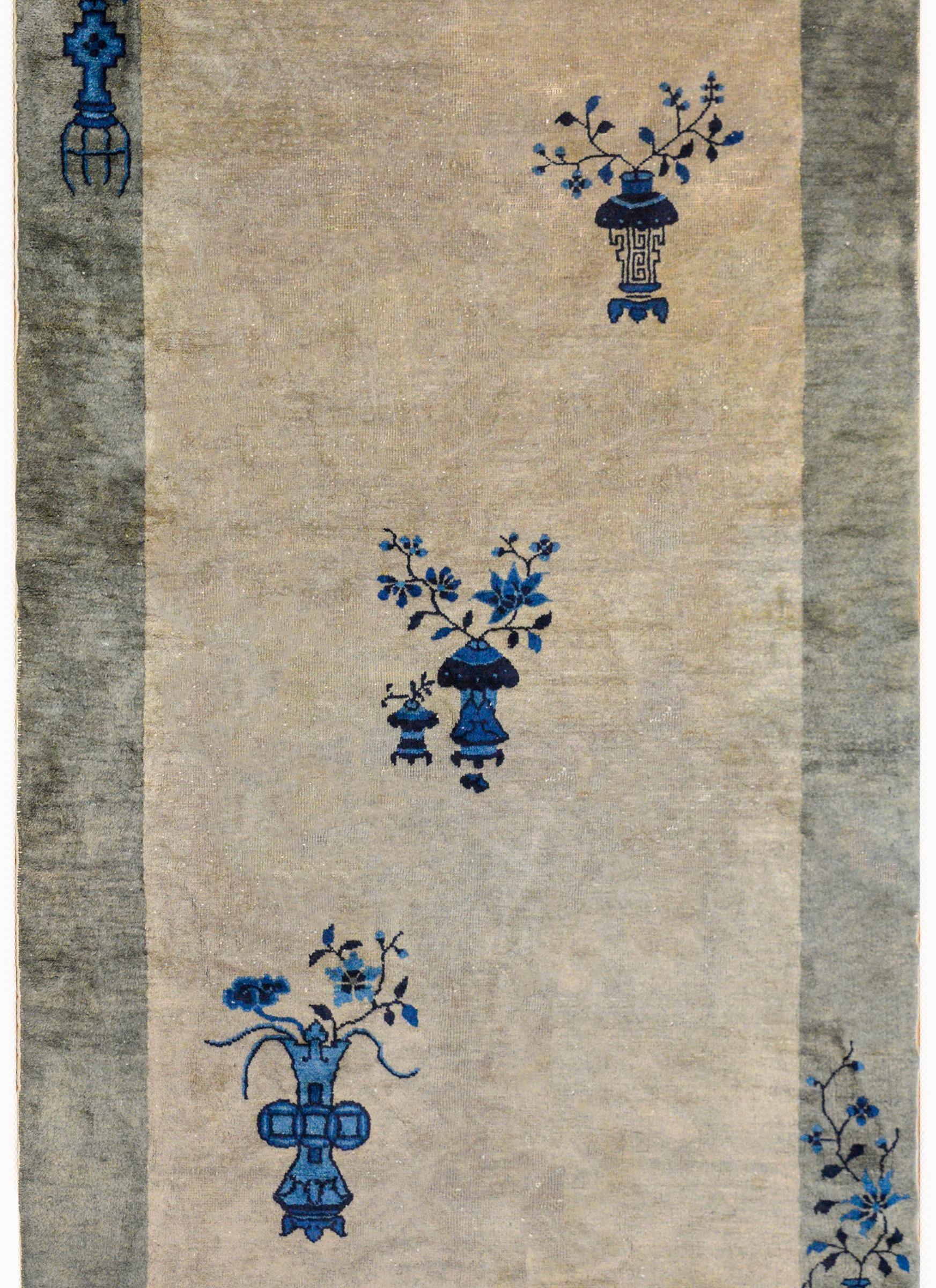 A wonderful Chinese Art Deco rug with a light gray field surrounded by a wide darker gray border. The field contains three potted vases with peonies and cherry blossoms while the border contains a vase potted with chrysanthemum and peonies in