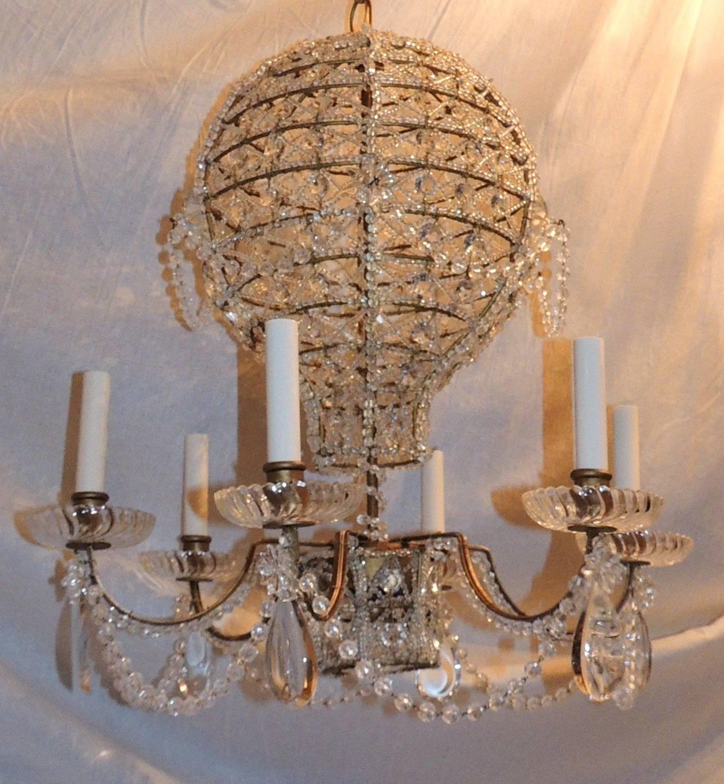 A wonderful pair cut-crystal hot air balloon complete with crystal basket has six arms
each with crystal drops and swirl crystal bobeches. The patina gold gilt soft aged distress that adds to the charm of this lovely chandelier adorned with beaded