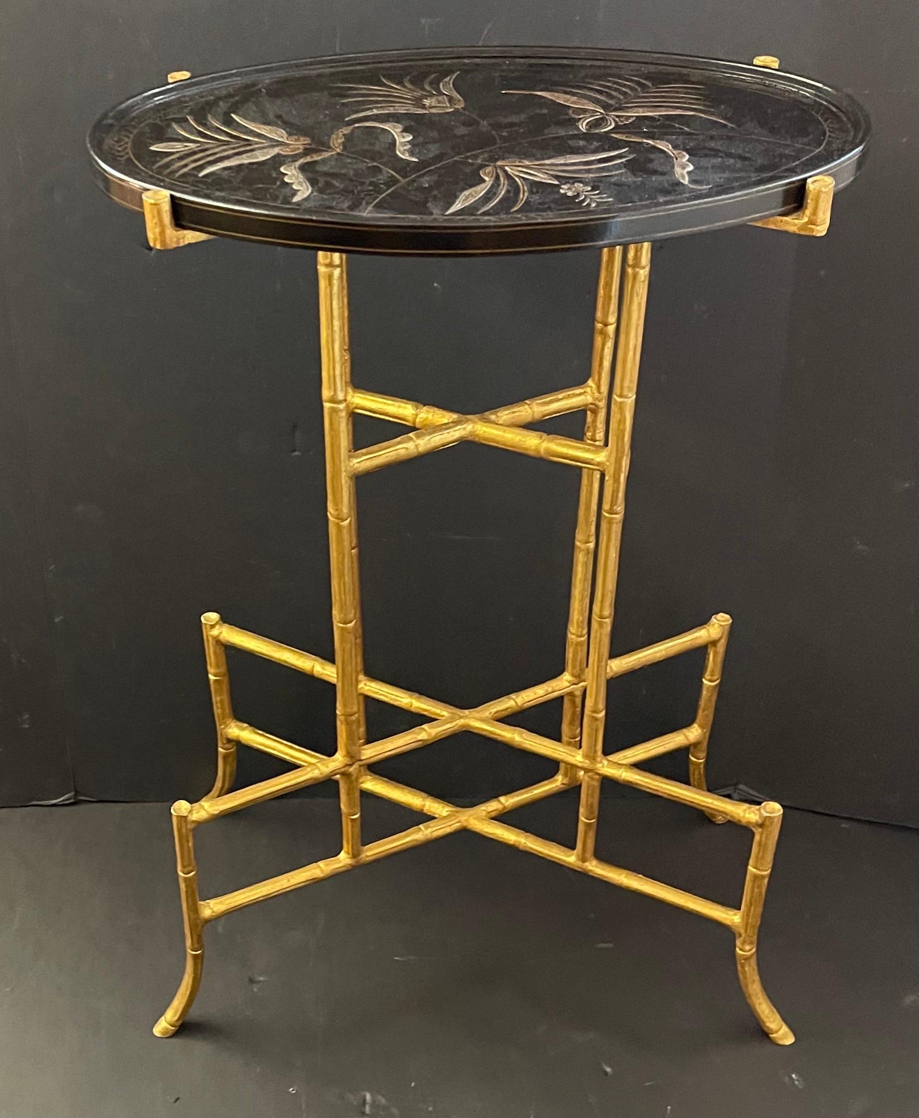 Wonderful Dessin Fournir oval wood top in black crackled lacquer finish with chinoiserie decoration occasional table, with hand-forged faux bamboo iron form base lags finished with 22 karat gold leaf.
Maker's label on underside. 
Measures: 27
