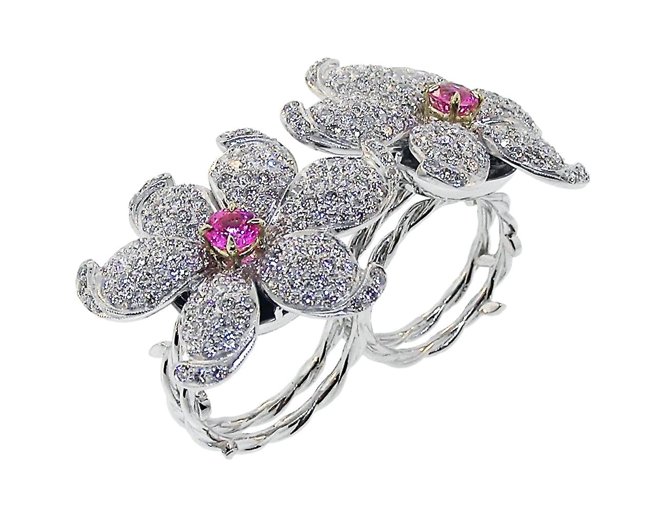 This great piece is of 18K White Gold with 8 Carats of Modern Round Brilliant good quality Diamonds.  The Flowers with a round Pink Sapphire set in 18K Yellow Gold. The shanks of a flower stalk design.

The Ring can be worn on any two fingers.  You